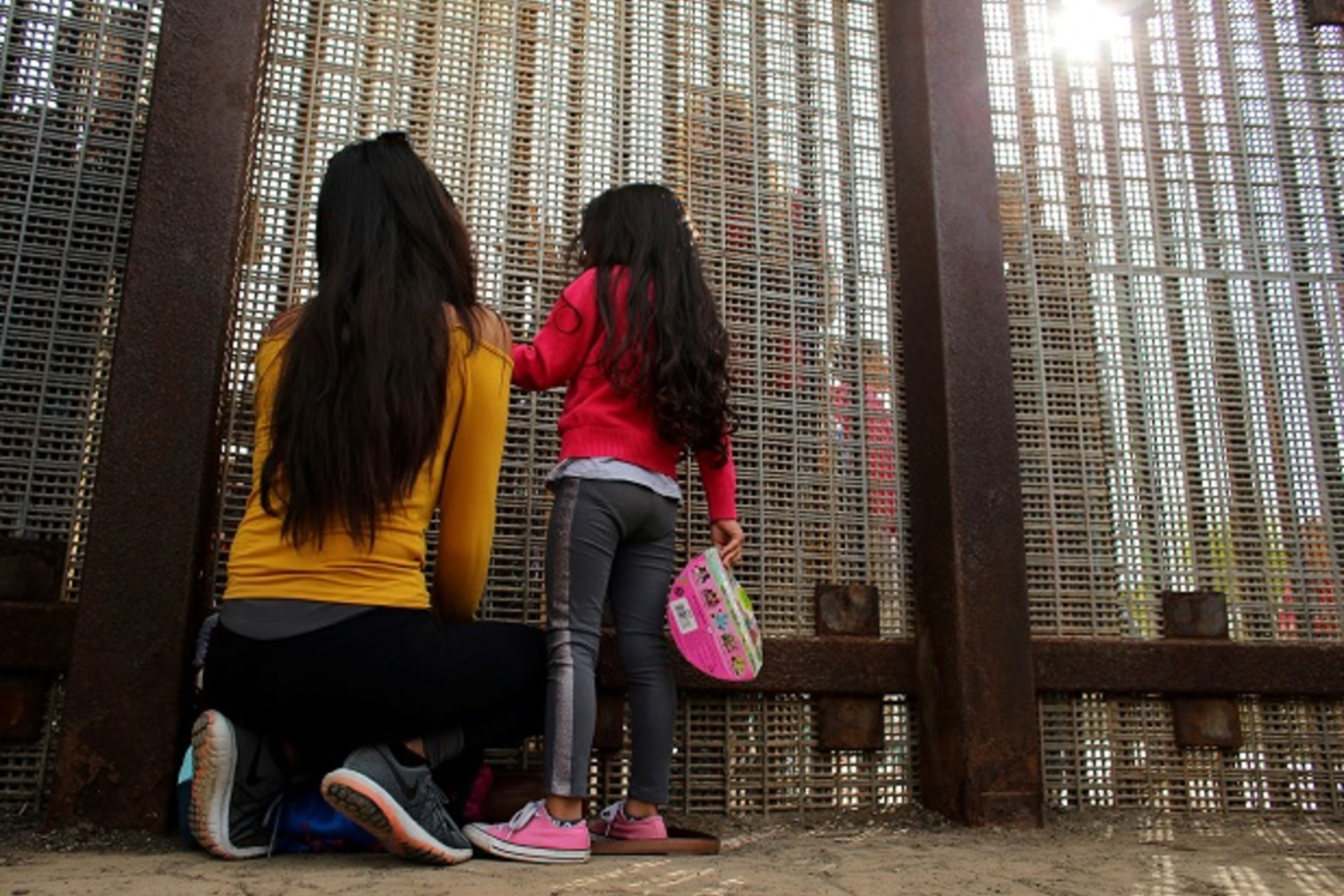 Families separated by the two countries chat along the U.S.-Mexico border fence at Border Field State Park, California