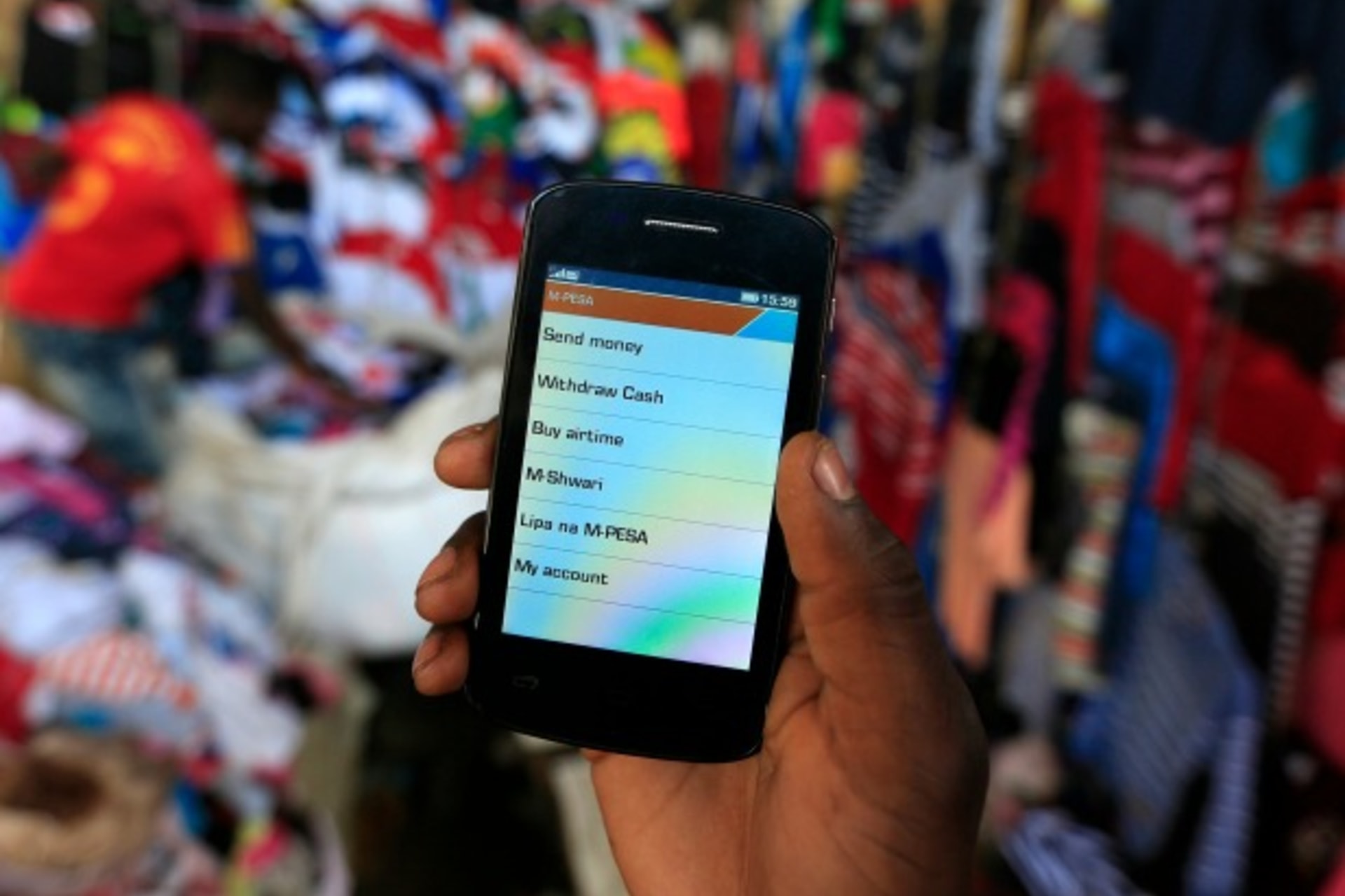 <p>A man holds up his mobile phone showing a M-Pesa mobile money transaction page for the photographer at an open air market in Kibera in Kenya’s capital Nairobi (Reuters/Noor Khamis).</p>
