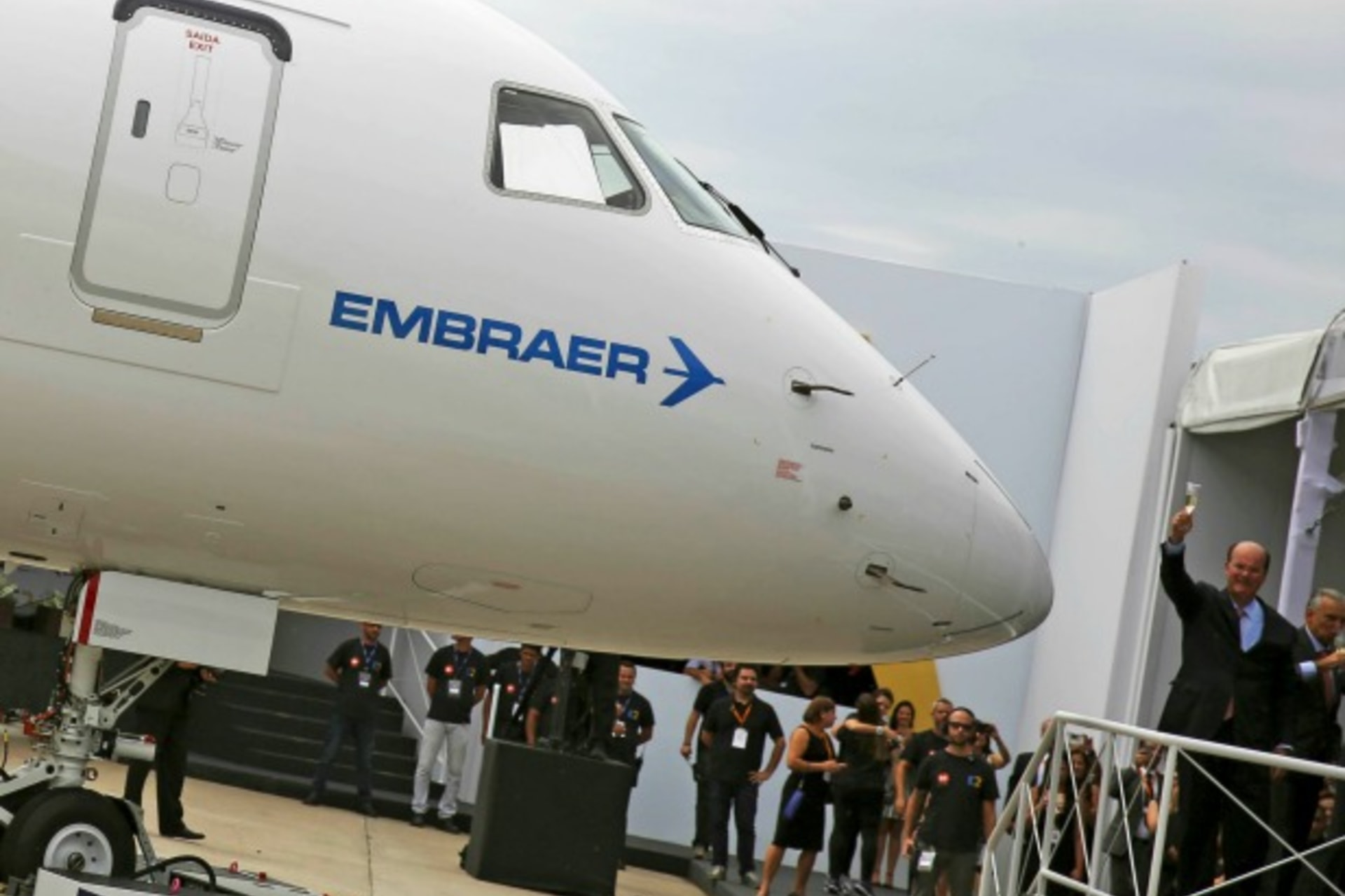 <p>Brazilian aircraft maker Embraer’s CEO Frederico Curado (R) salutes workers next to an new Embraer E190-E2 during its unveil i…ation, following the end of international sanctions, Chief Executive Curado told journalists on Thursday (Reuters/Nacho Doce).</p>

