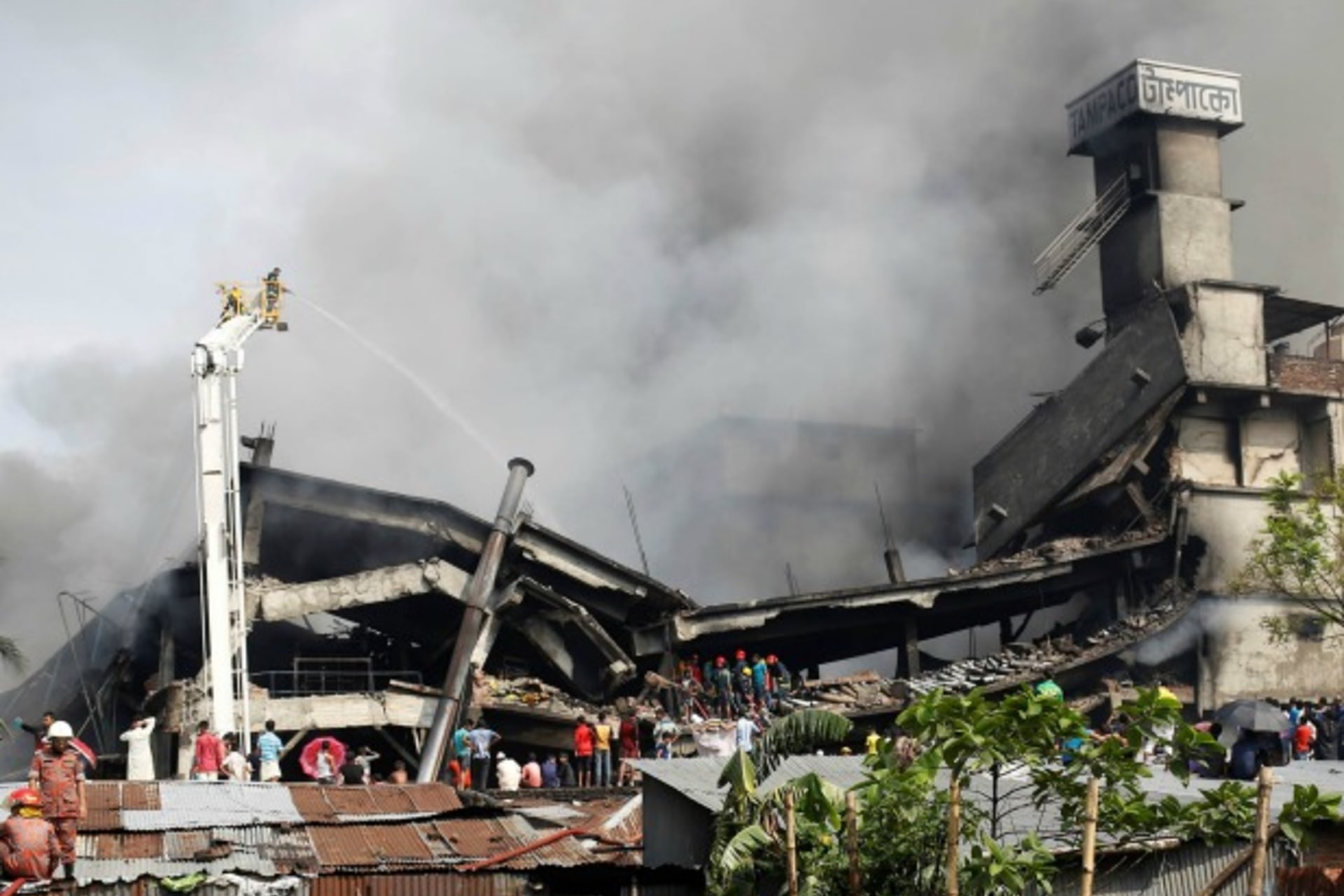<p>Firefighters extinguish a fire at a food and cigarette packaging factory outside of Dhaka, Bangladesh, September 10, 2016 (Reuters/Mohammad Ponir Hossain).</p>
