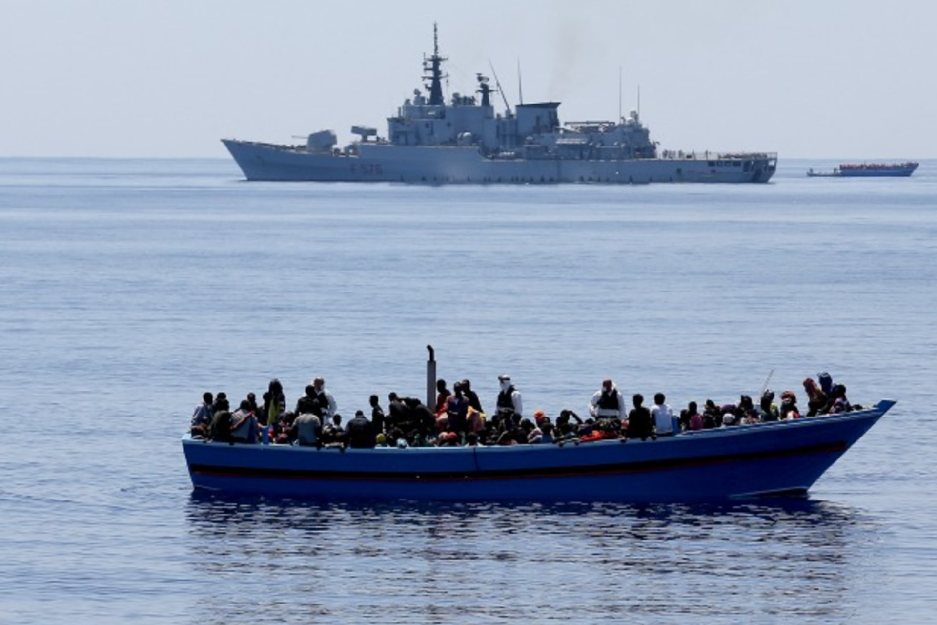 <p>A group of 300 sub-Saharan Africans on board a boat are seen next to an Italian marine ship (top) during a rescue operation by…ts were rescued off the coast of Sicily, about 130 miles from Lampedusa, according to the police. (Alessandro Bianchi/Reuters)</p>
