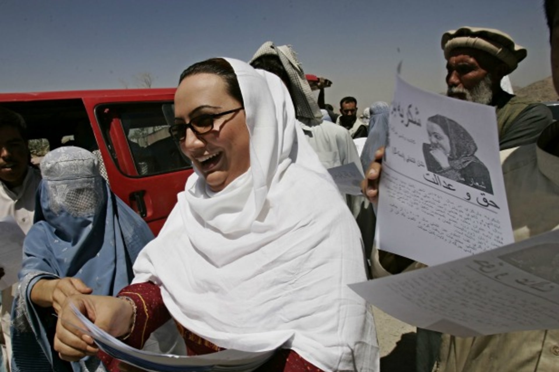 <p>Shukria Barakzai, a member of parliament, hands out leaflets during her August 2005 election campaign in Kabul, Afghanistan. Barakzai later survived a suicide bombing attack in December 2014 (Courtesy Zohra Bensemra/Reuters).</p>