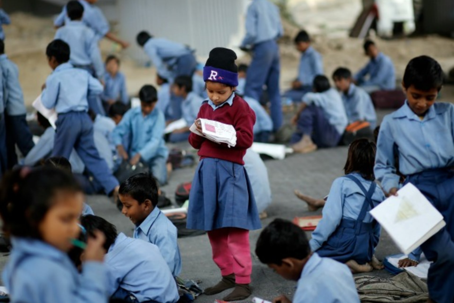 <p>A schoolgirl reads from a textbook at an open-air school in New Delhi, India, November 2014 (Courtesy Reuters/Anindito Mukherjee).</p>