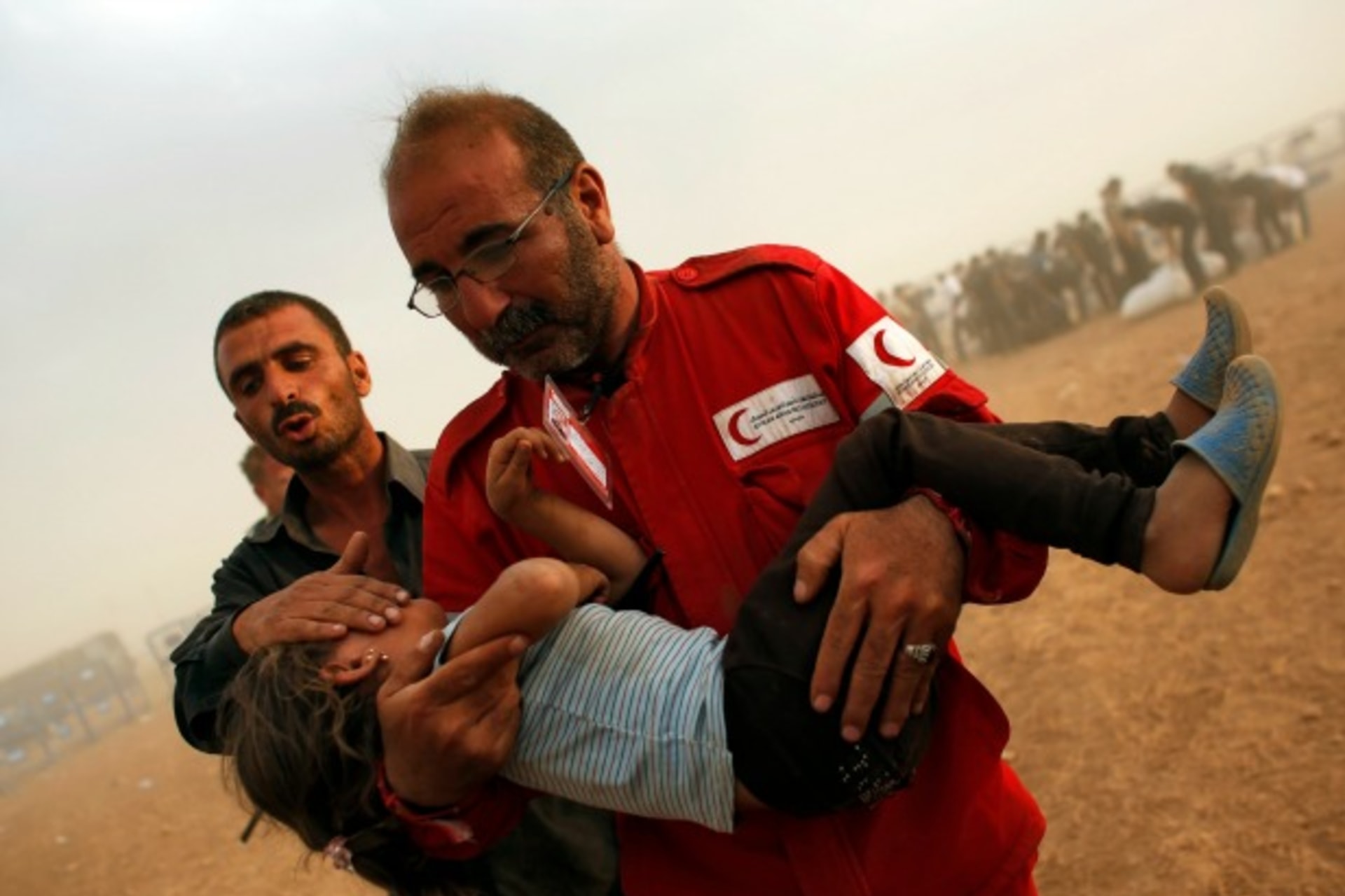 <p>A member of the Syrian Arab Red Crescent carries a Kurdish Syrian refugee girl to the first aid tent after crossing the Turkish-Syrian border near the southeastern town of Suruc in Sanliurfa province, Turkey, September 2014 (Courtesy Reuters/Murad Sezer).</p>
