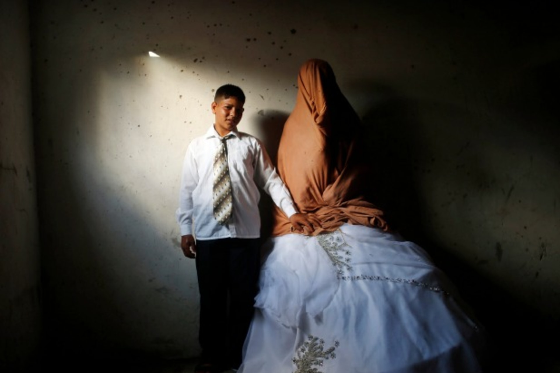 <p>Ahmed Soboh, age 15, stands next to his bride Tala, age 14, inside Tala’s house in the town of Beit Lahiya, near the border be…Strip. Ahmed works with his father as a road cleaner earning $5 per day. September 24, 2013 (Courtesy Reuters/Mohammed Salem).</p>
