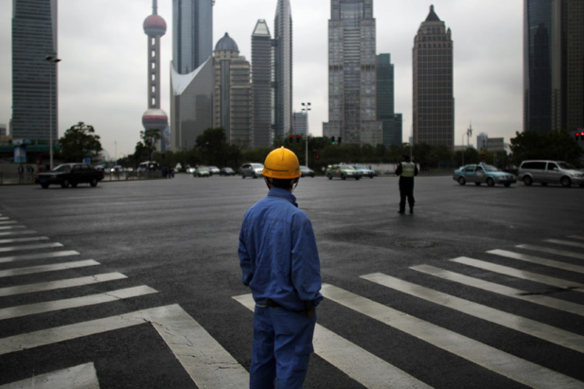 <p>A construction worker looks at the Pudong financial district in Shanghai (Carlos Barria/Courtesy Reuters).</p>