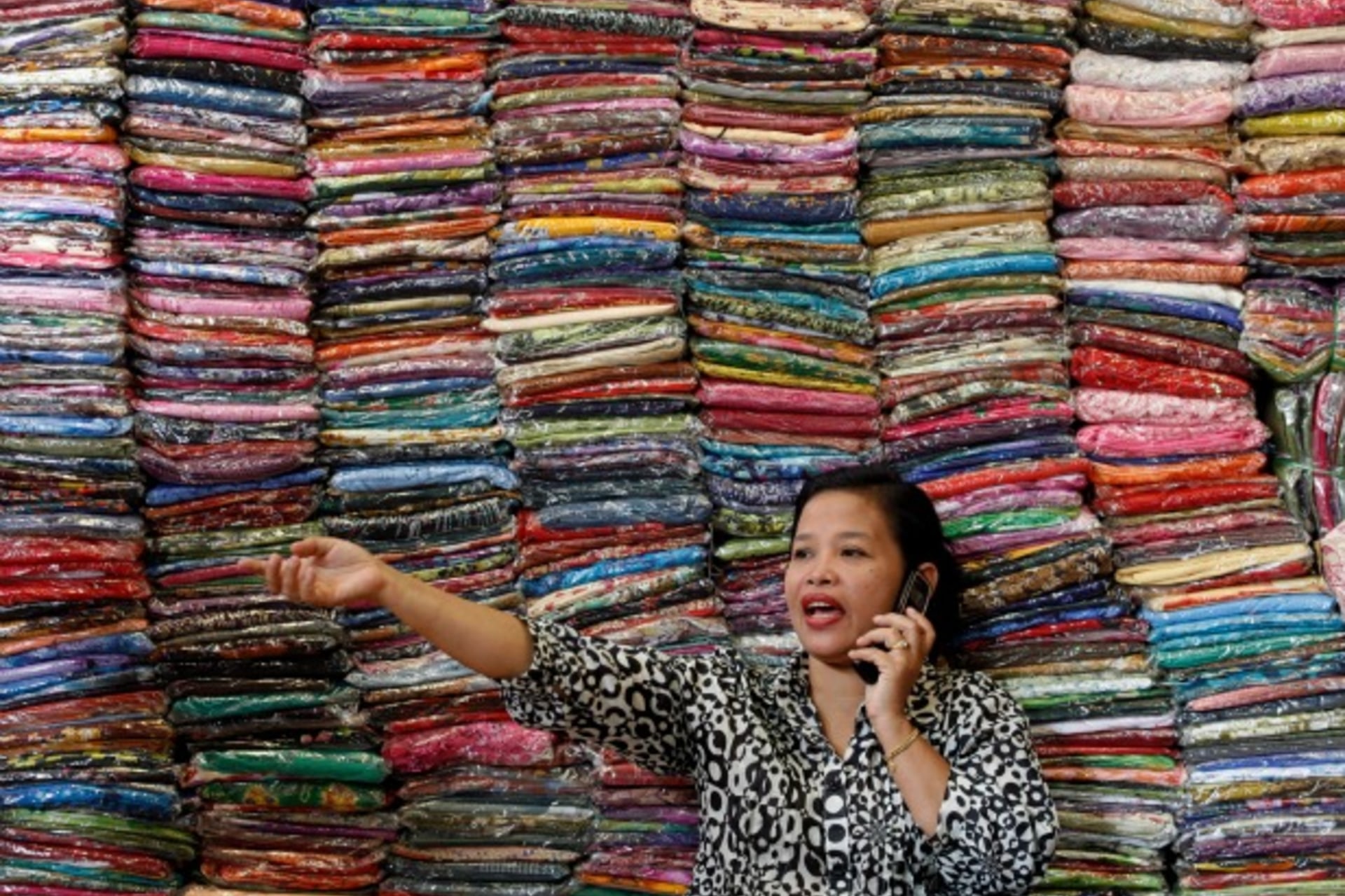 <p>Fadhilah Arshad, a Malaysian businesswoman, talks to a supplier as she sells cloth at her bazaar in Kuala Lumpur, December 2009. (Courtesy Reuters/Bazuki Muhammad).</p>
