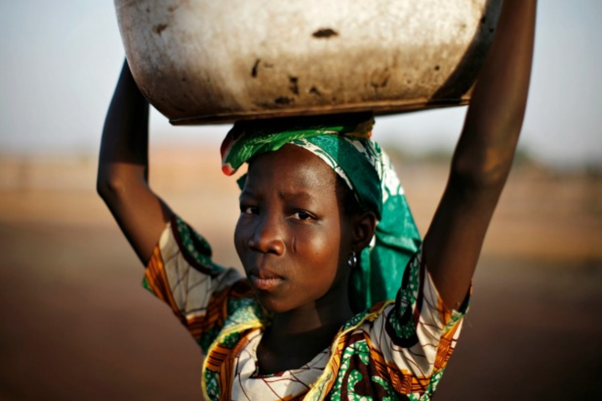 <p>A Ghanian girl carries water in the northern city of Tamale, January 24, 2008 (Finbarr O’Reilly/Courtesy Reuters).</p>
