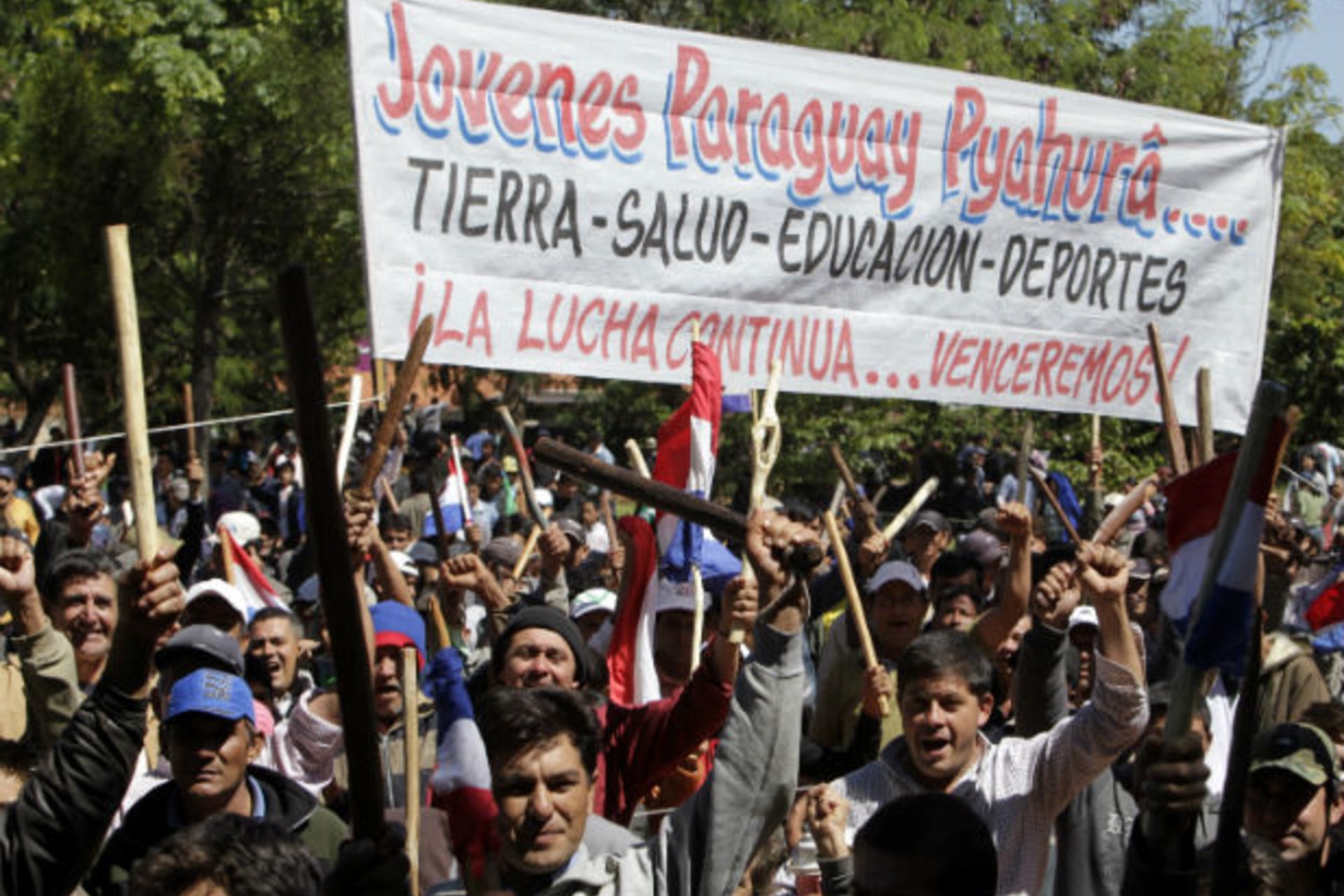 <p>Paraguayan peasants hold up pieces of wood as they arrive in Auncion for the annual “March of the rural poor” on March 28, 2012 (Jorge Adorno/Courtesy Reuters).</p>
