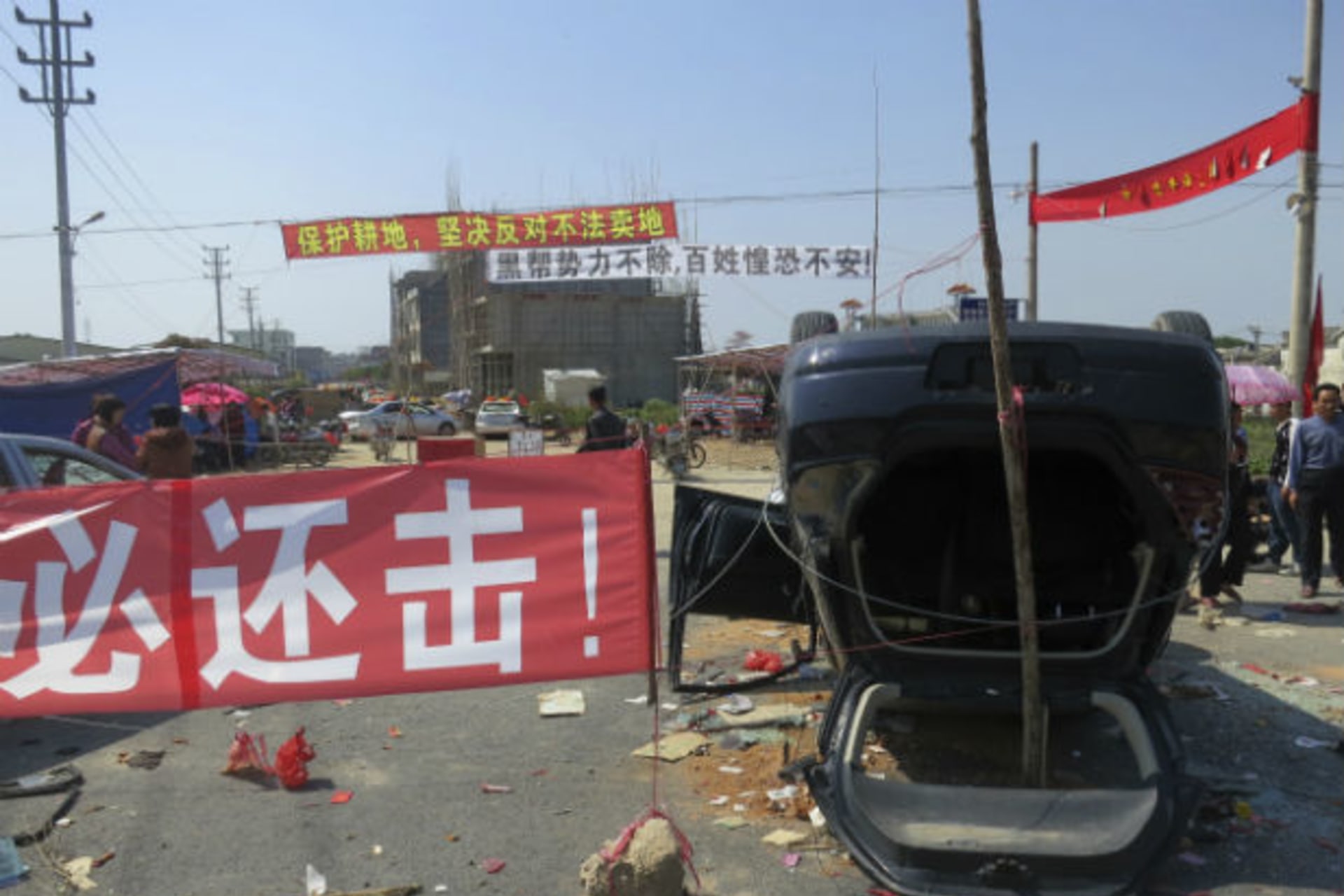 <p>DATE IMPORTED:March 7, 2013A red sign “We must retaliate” is displayed next to an upended car at the entrance of Shangpu village, in China’s southern Guangdong province on March 5, 2013 (James Pomfret/Courtesy Reuters).</p>

