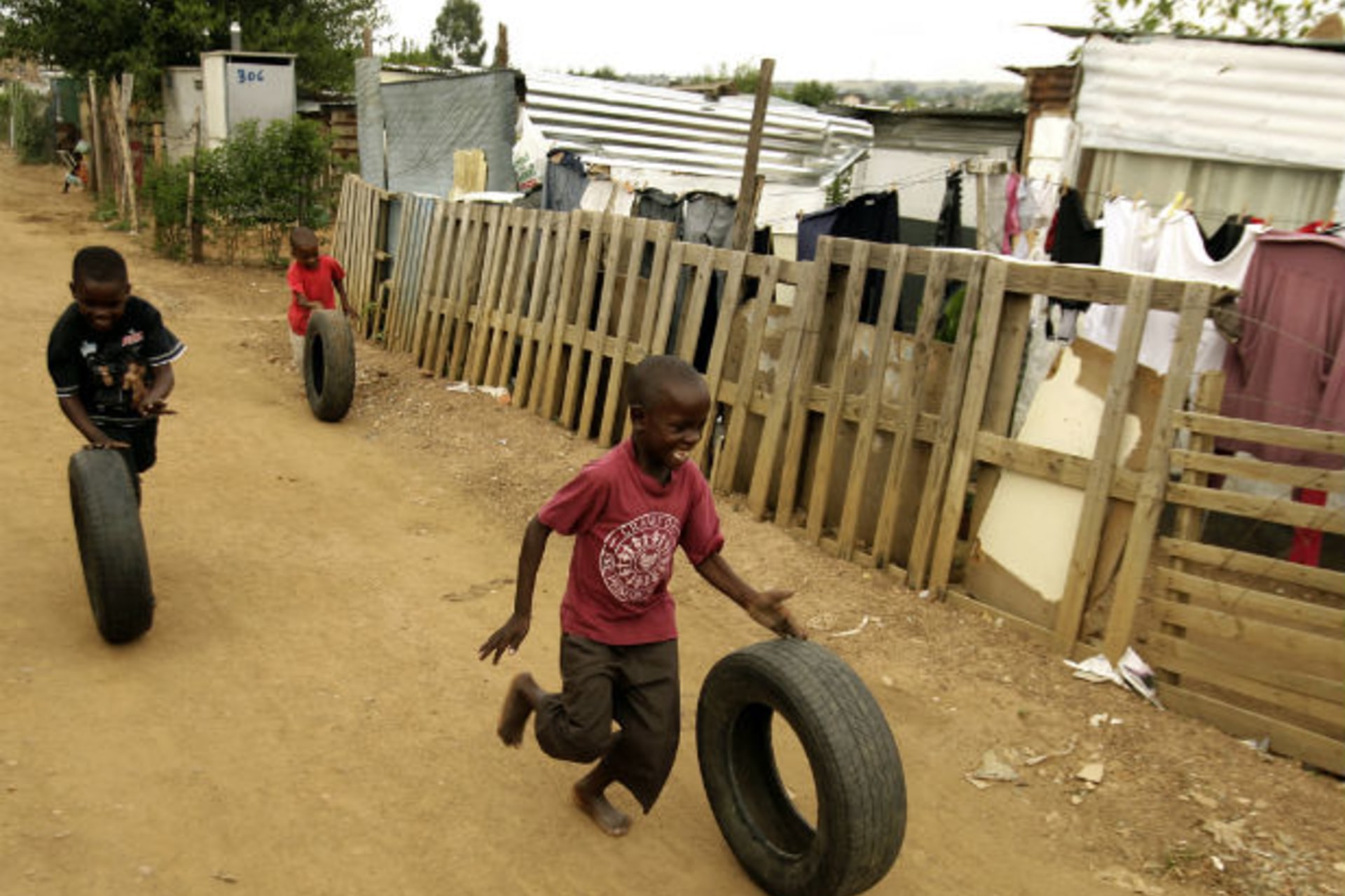 <p>Young boys play with car tyres in a township outside Johannesburg on January 25,2009 (Siphiwe Sibeko/Courtesy Reuters).</p>
