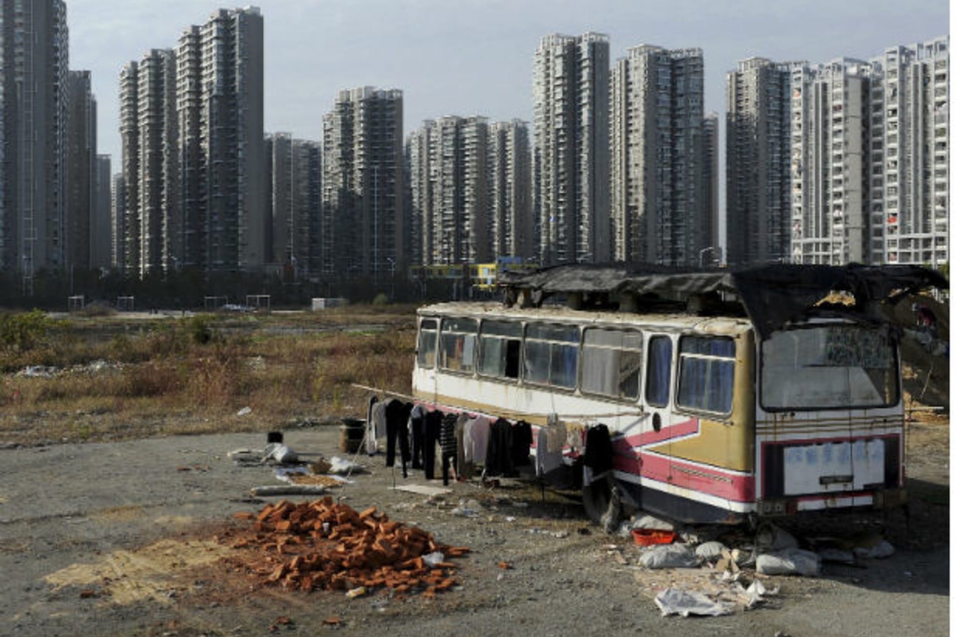 <p>Clothes are seen hanging outside a bus which has been converted into a dwelling for Lu Changshan and his wife, near newly-constructed residential buildings in Hefei, Anhui province on November 12, 2012 (Jianan Lu/Courtesy Reuters).</p>