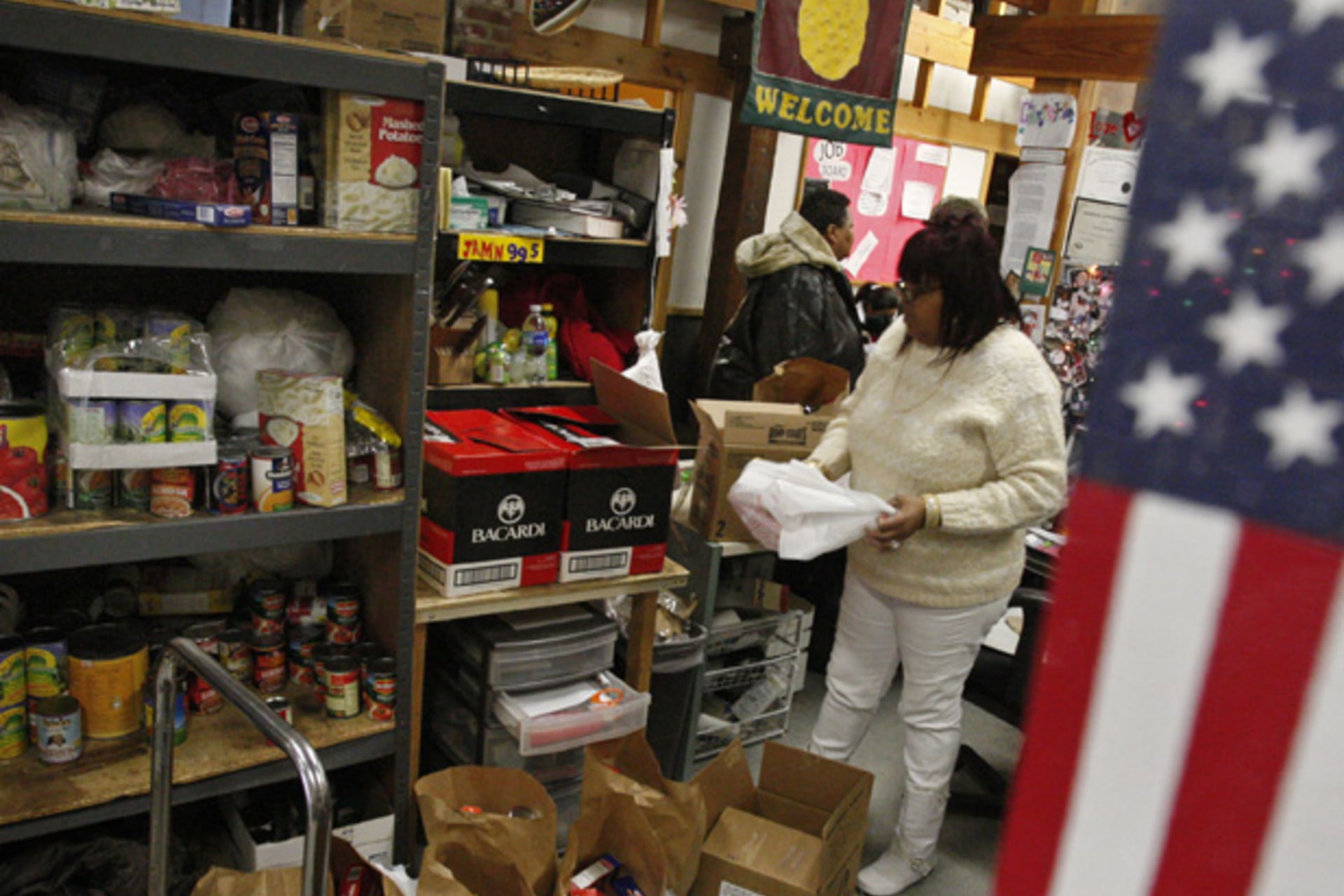 <p>A coordinator at Bread for the City food pantry in Washington, DC fills up a bag of food to distribute (Jim Young/Courtesy Reuters).</p>
