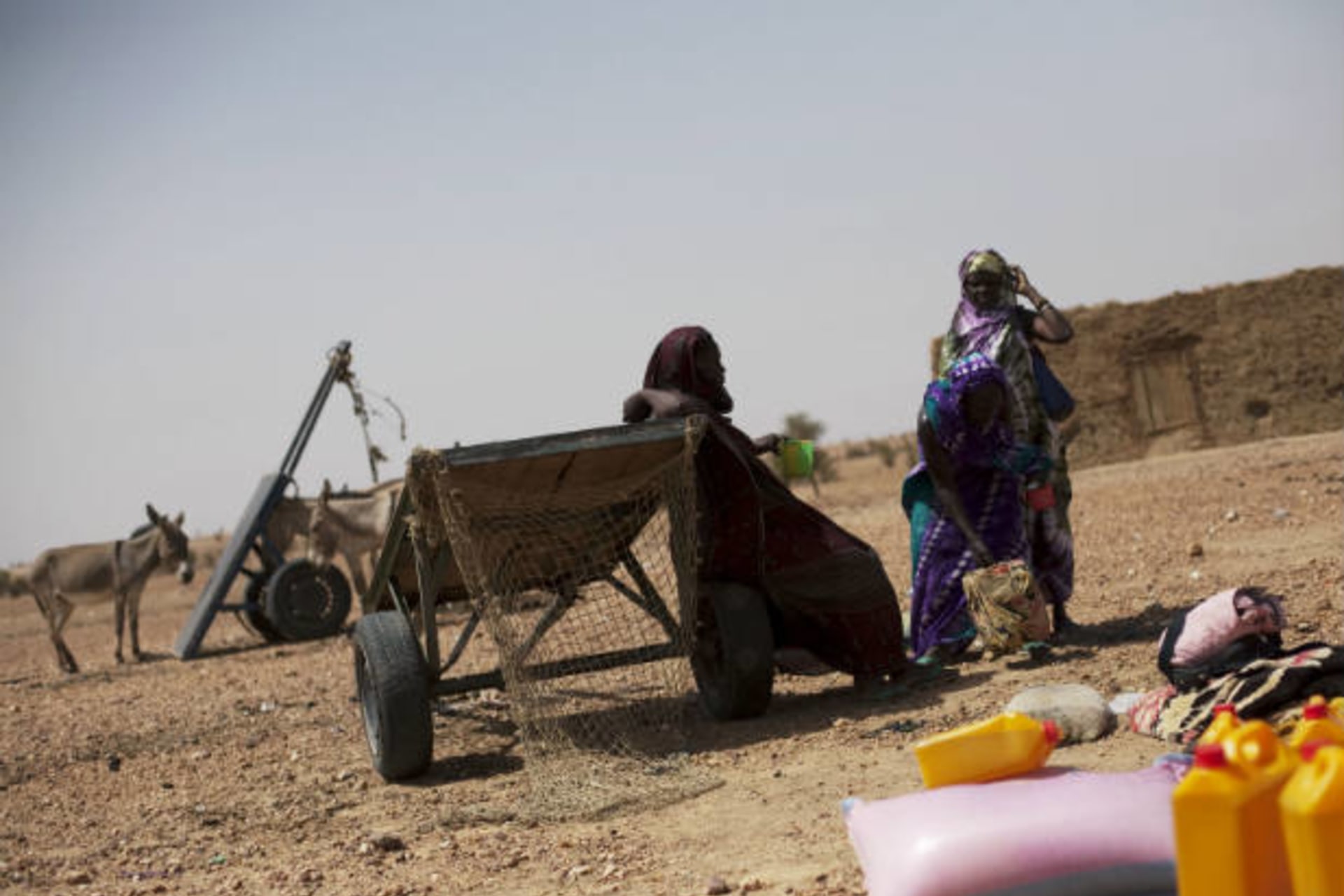<p>Women wait to load their cart with bags of rice and bottles of cooking oil at a food distribution center run by the Spanish No…a el Hambre (Action against Hunger) in Tarenguel, Gorgol region, in Mauritania on May 30, 2012 (Susana Vera/Courtesy Reuters).</p>
