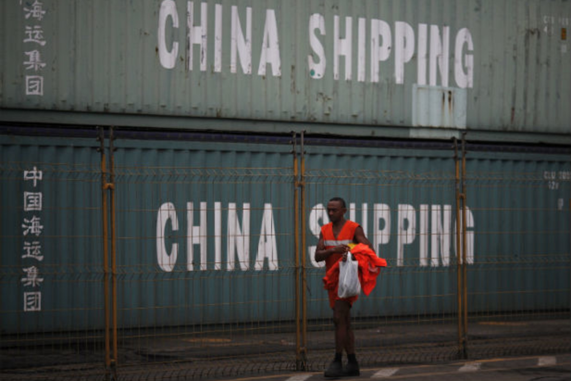 <p>Worker walks past by containers from China Shipping company at Brazil’s main ocean port of Santos city</p>
