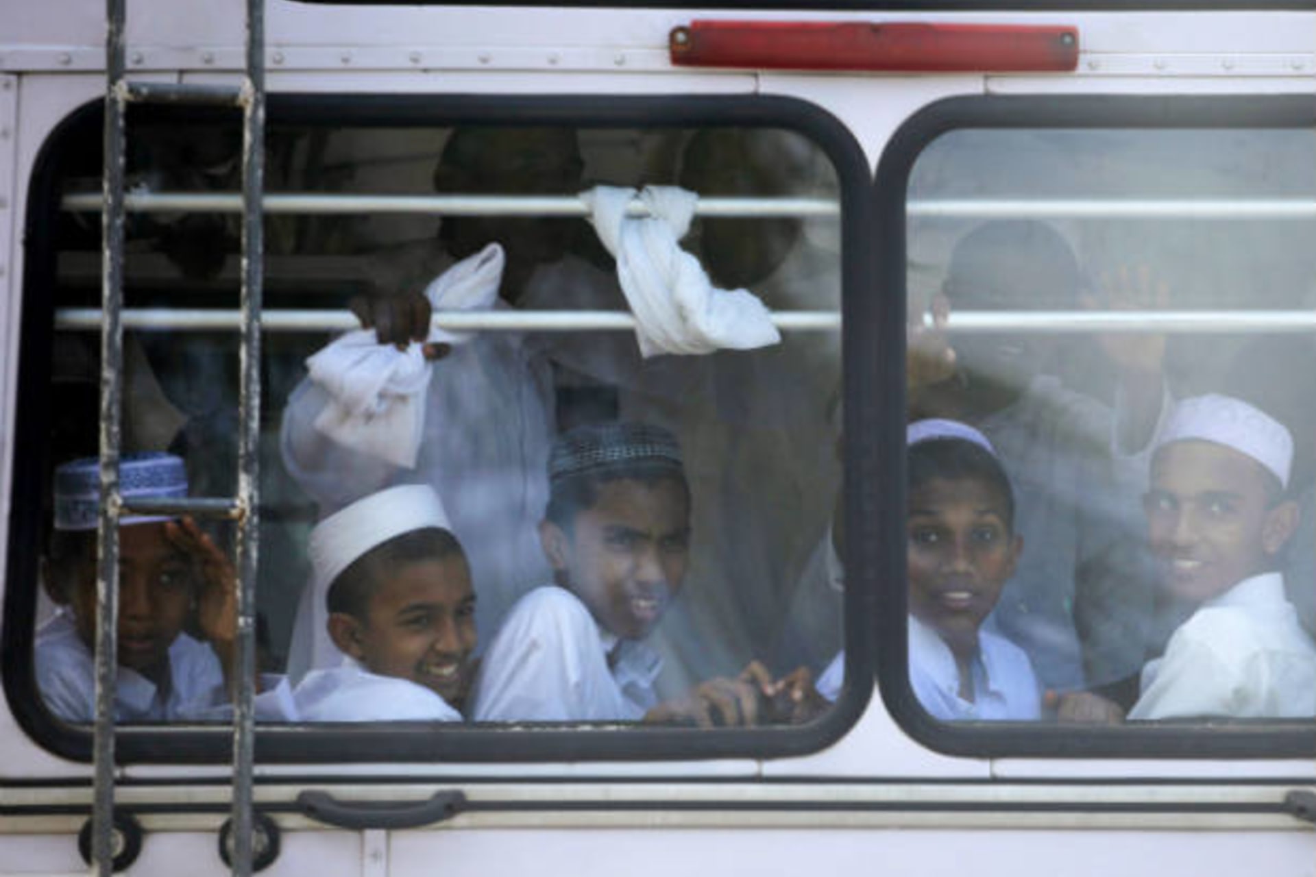 <p>Boys look out of a window on bus as they return from school in Colombo, Sri Lanka on October 4, 2009 (Carlos Barria/Courtesy Reuters).</p>
