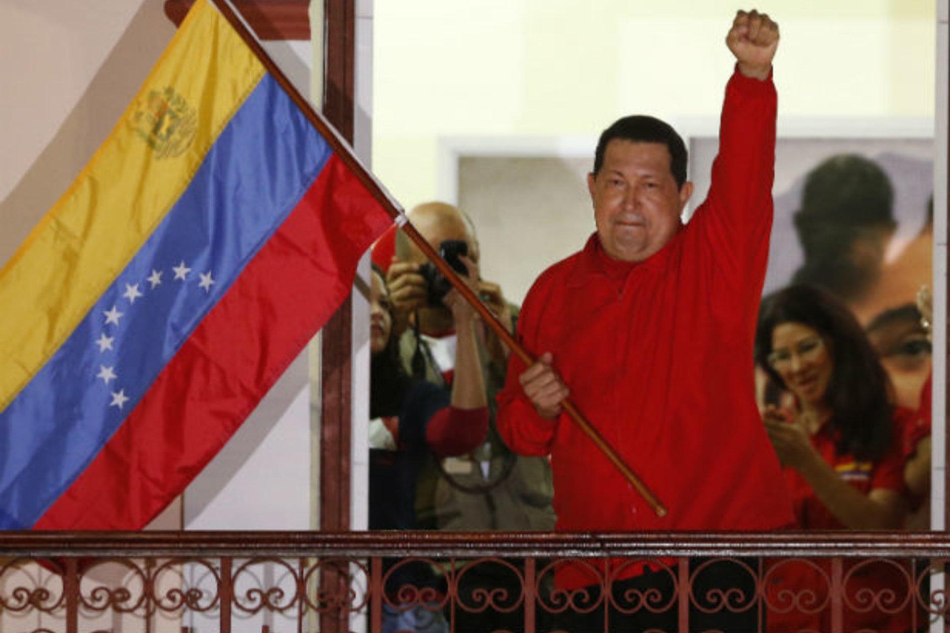 <p>Venezuelan President Hugo Chavez waves the national flag while celebrating from a balcony at Miraflores Palace in Caracas (Jorge Silva/Courtesy Reuters).</p>
