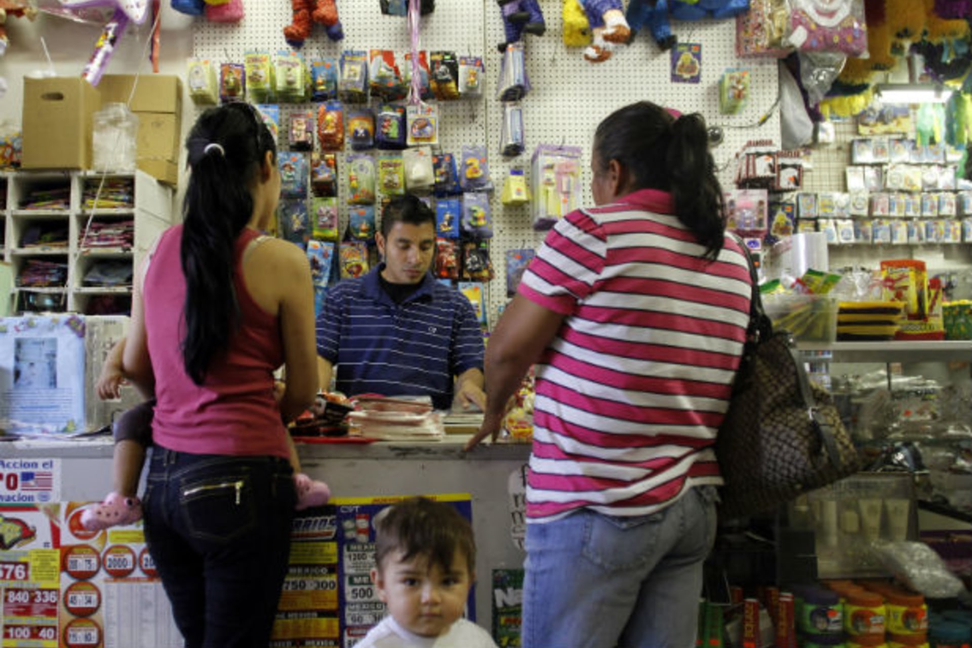 <p>Oswaldo Alvarado helps customers at Importaciones Valentinas grocery and pinata store in Phoenix</p>
