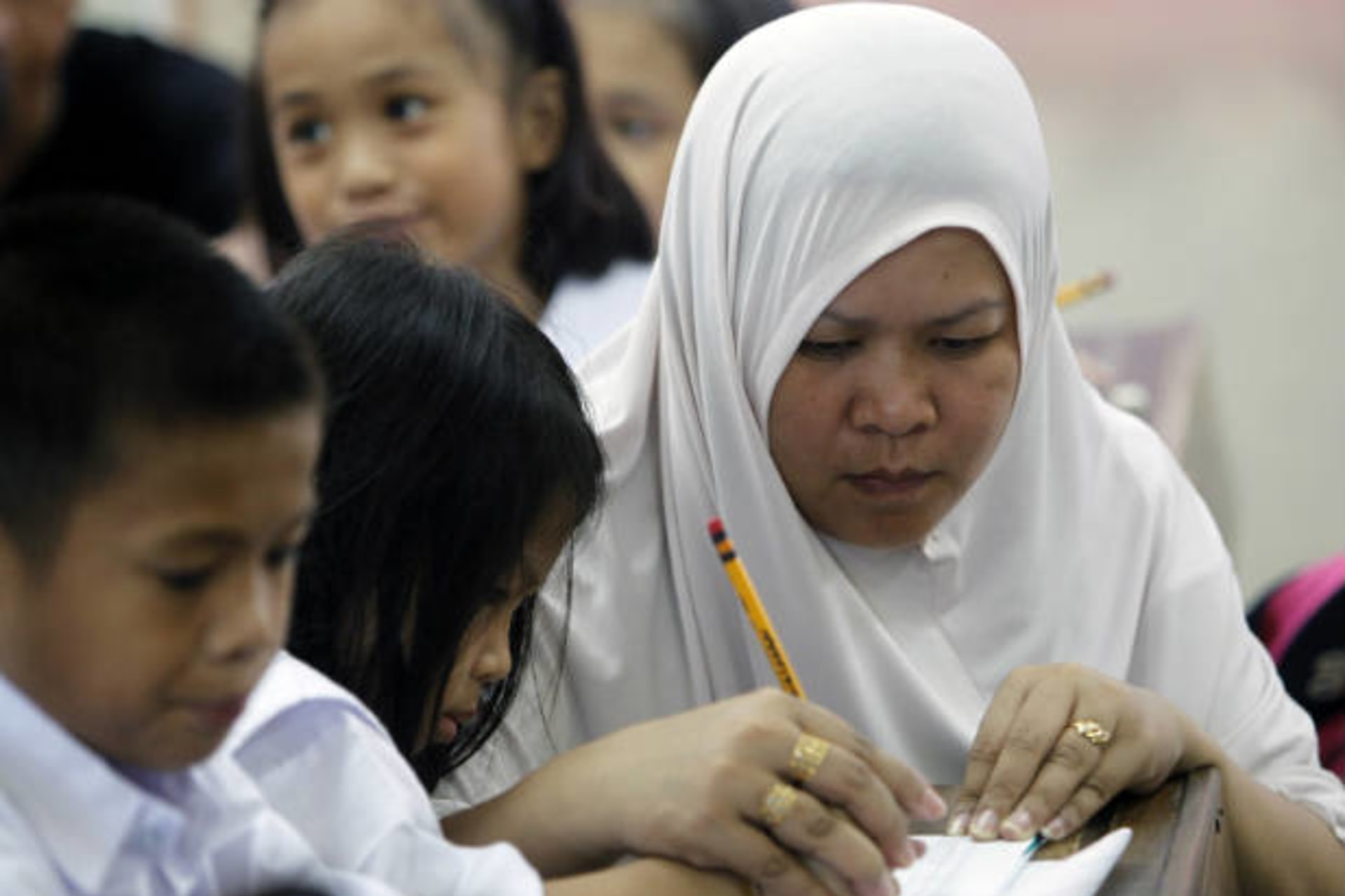 <p>A mother assists her daughter on her first day of school in Manila, Philippines on June 15, 2010 (Romeo Ranoco/Courtesy Reuters).</p>