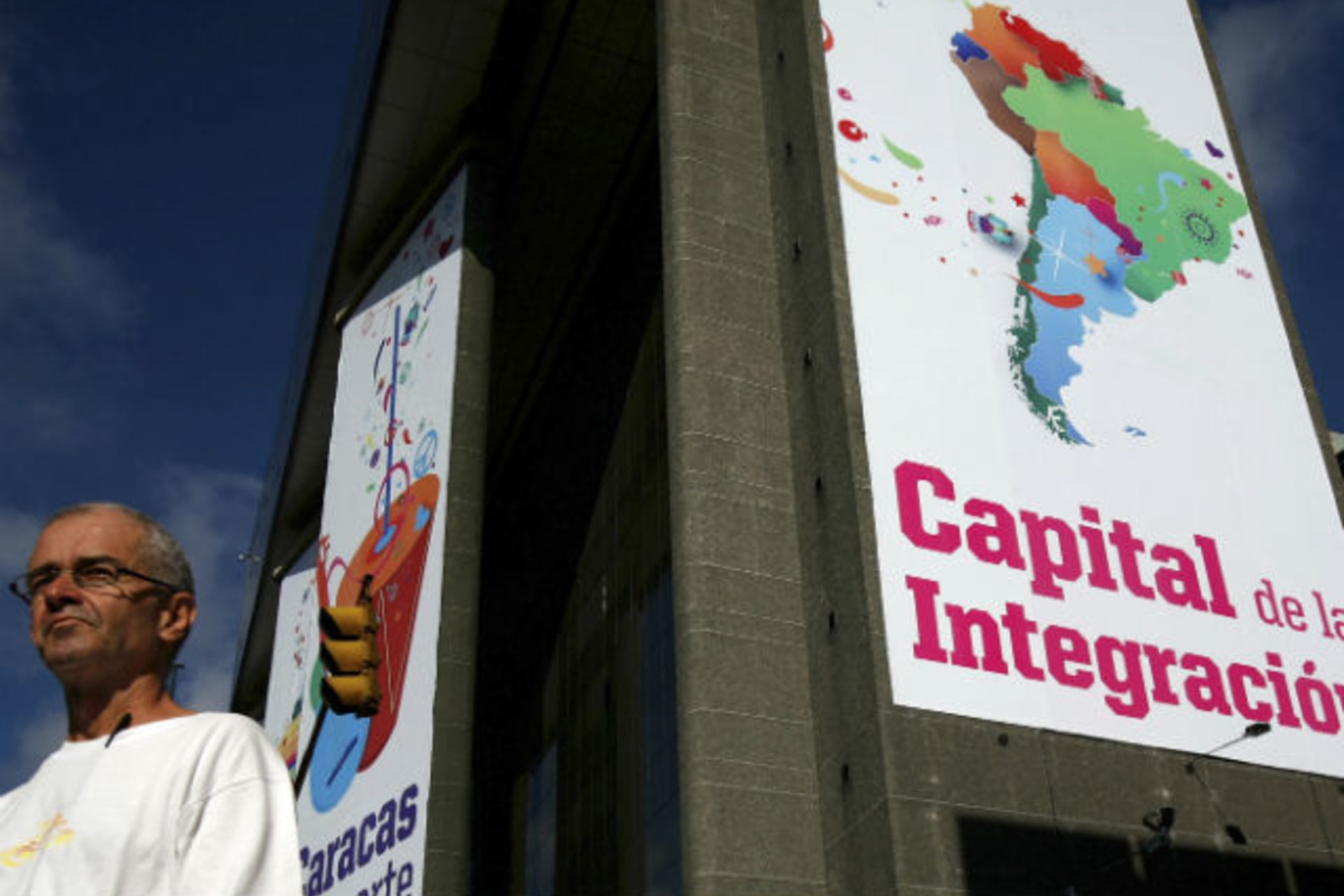 <p>A man walks past a banner reading ‘Capital of integration’ in Caracas</p>
