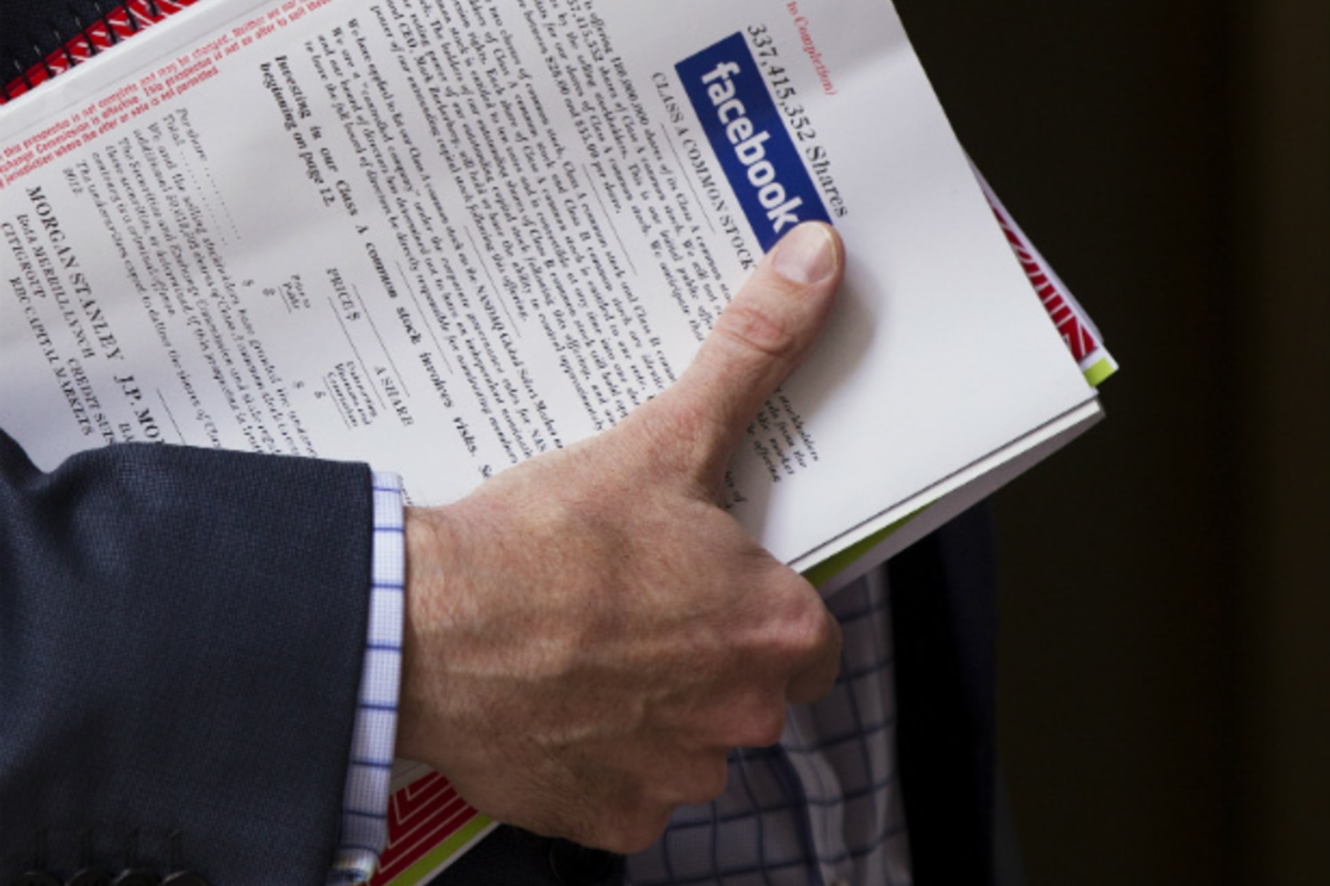 <p>A man in New York holds a pamphlet of information on investing in Facebook’s IPO. (Lucas Jackson/Courtesy Reuters).</p>
