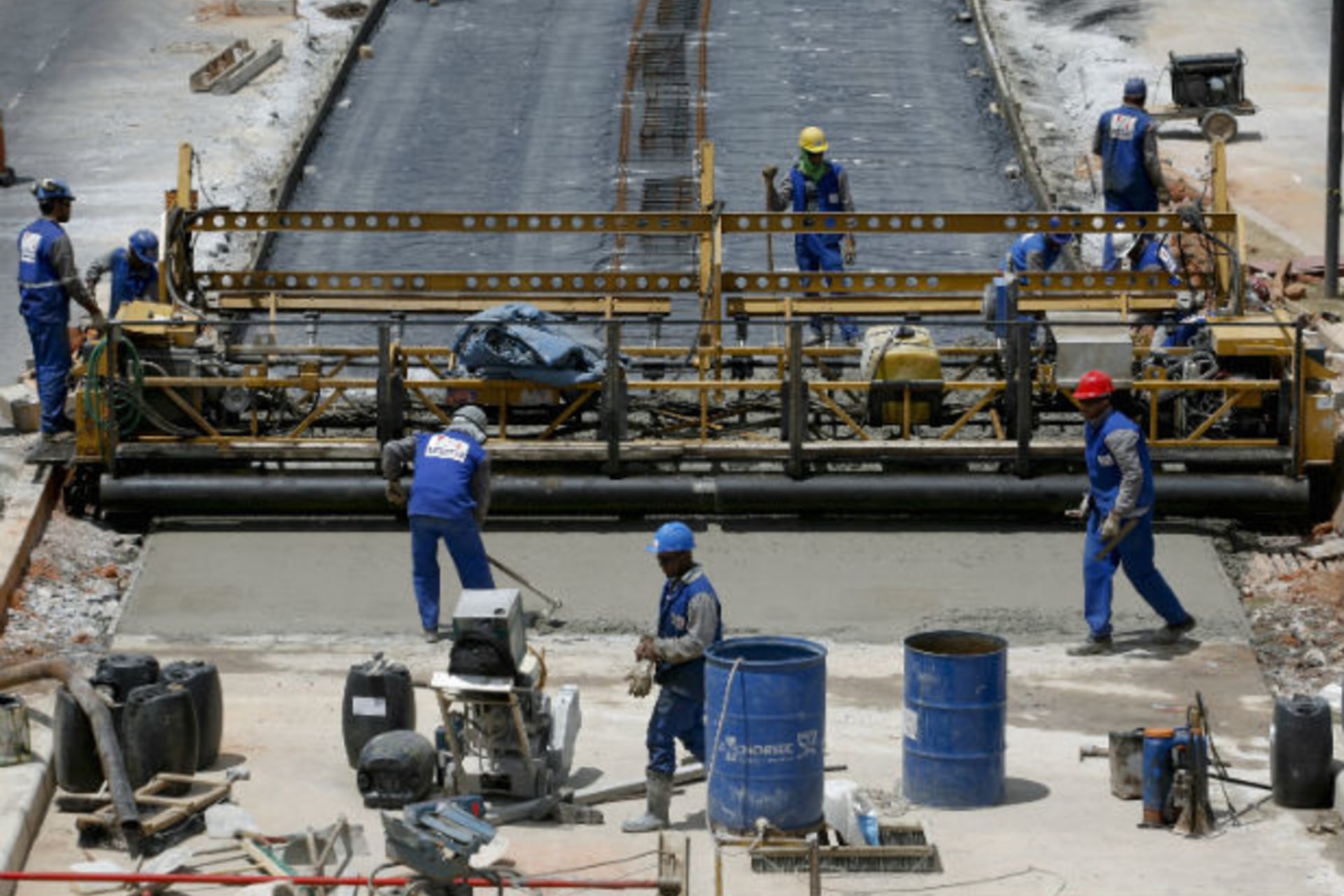 <p>Workers spread cement for a new bus lane projected to carry more passengers during the 2014 World Cup, in Belo Horizonte</p>

