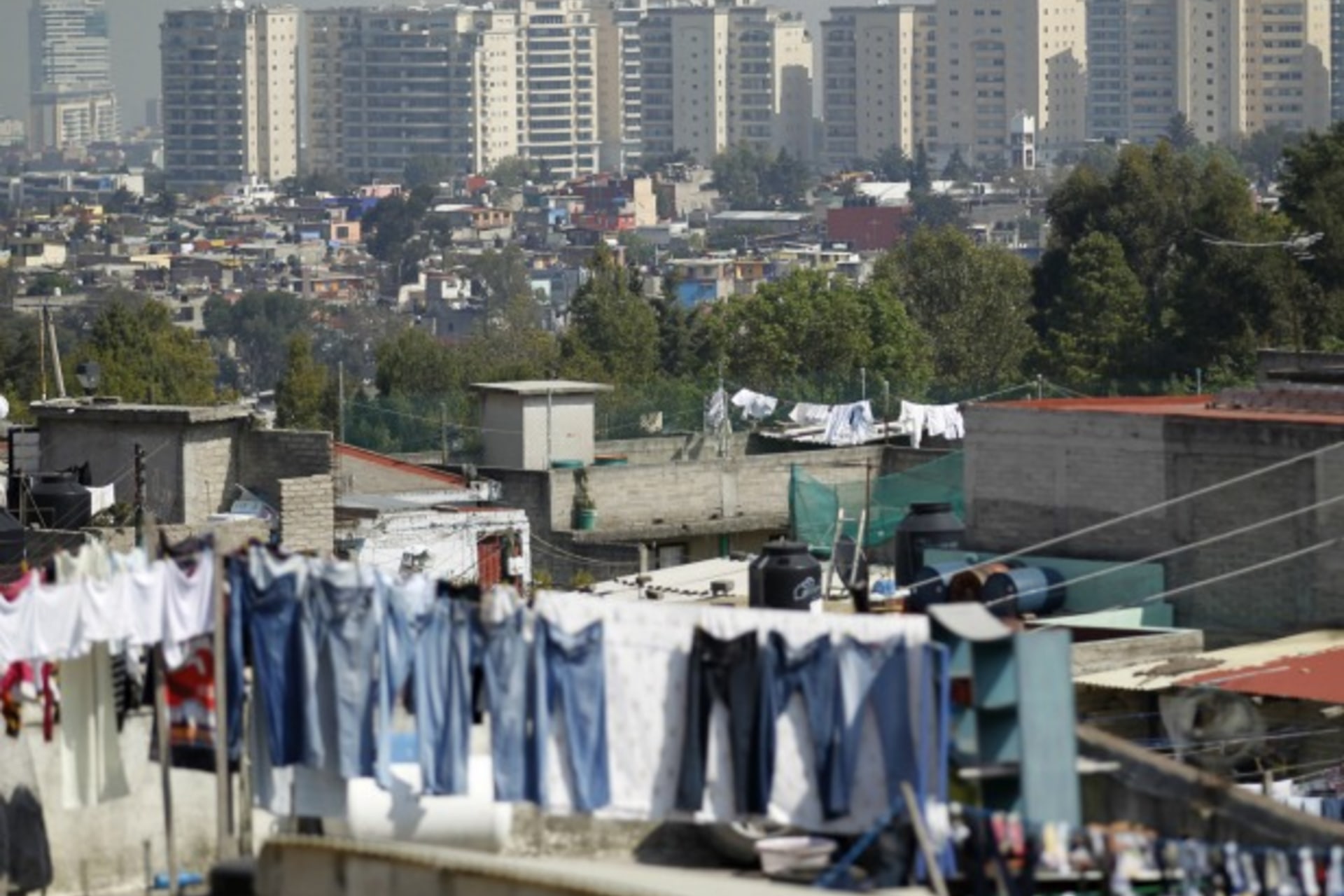 <p>Apartment buildings stand behind a low-income neighborhood in Mexico City</p>
