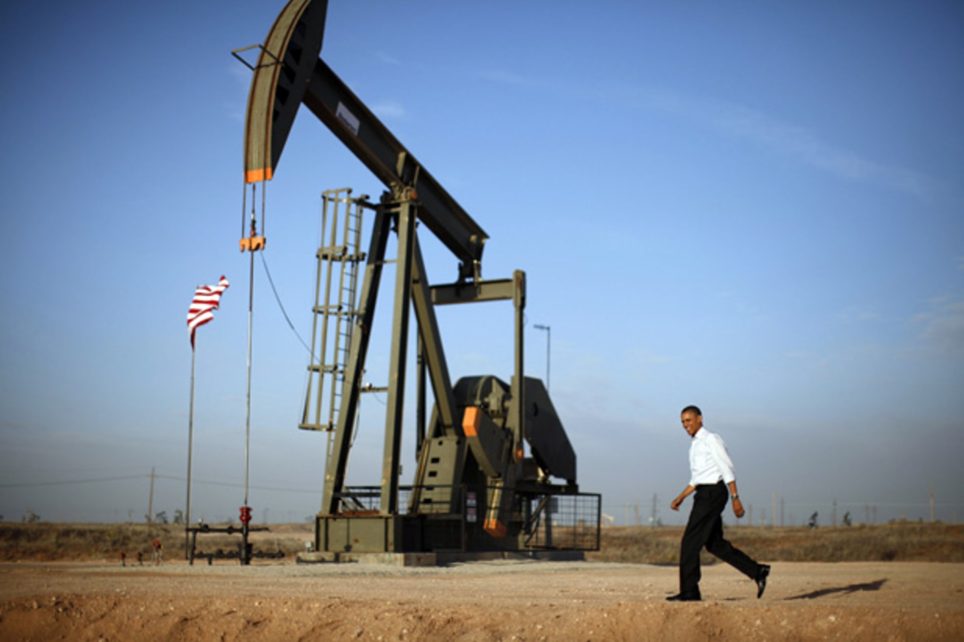 U.S. President Barack Obama walks past a pumpjack in Maljamar