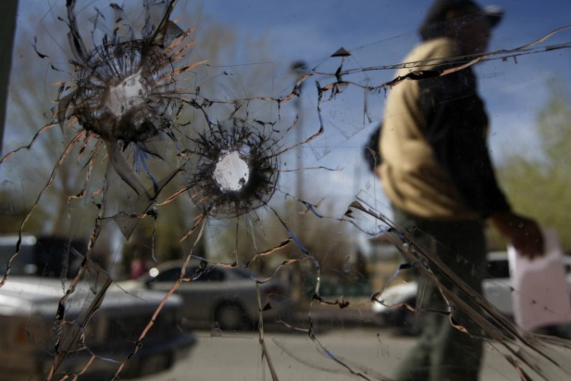 A person walks past a glass door damaged by bullets at the police headquarters where Marisol Valles Garcia used to work in Praxedis G. Guerrero