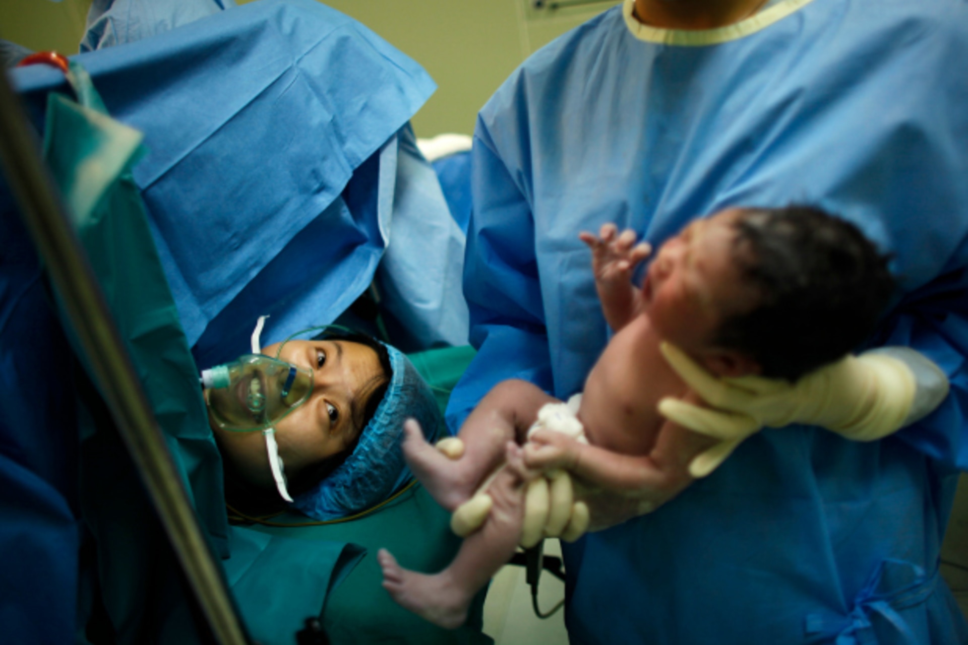 <p>Yang Huiqing looks at her baby after a cesarean section in Ruijin Hospital in Shanghai</p>
