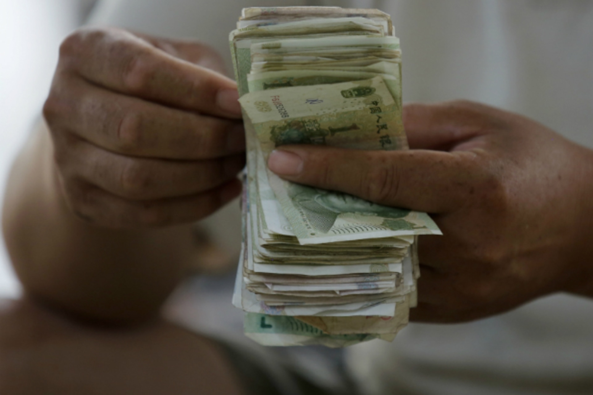 <p>A vendor counts Chinese Yuan banknotes at a market in Beijing on August 9, 2013. China’s consumer inflation steadied in July although factory-gate deflation persisted for a 17th month, official data showed on Friday. (Kim Kyung Hoon/Courtesy Reuters)</p>