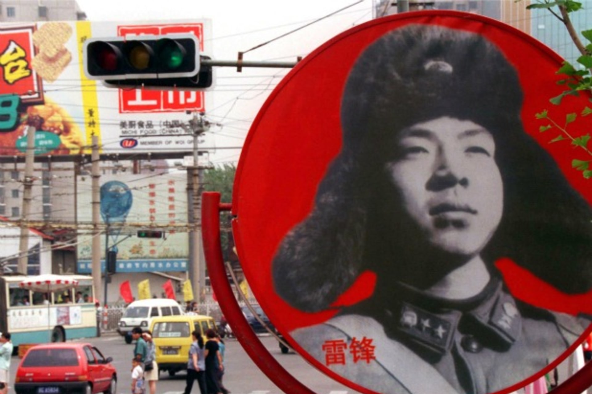 <p>A portrait of Chinese national folk-hero, Lei Feng looks out over a busy intersection in a central Beijing shopping district in June of 1998.</p>