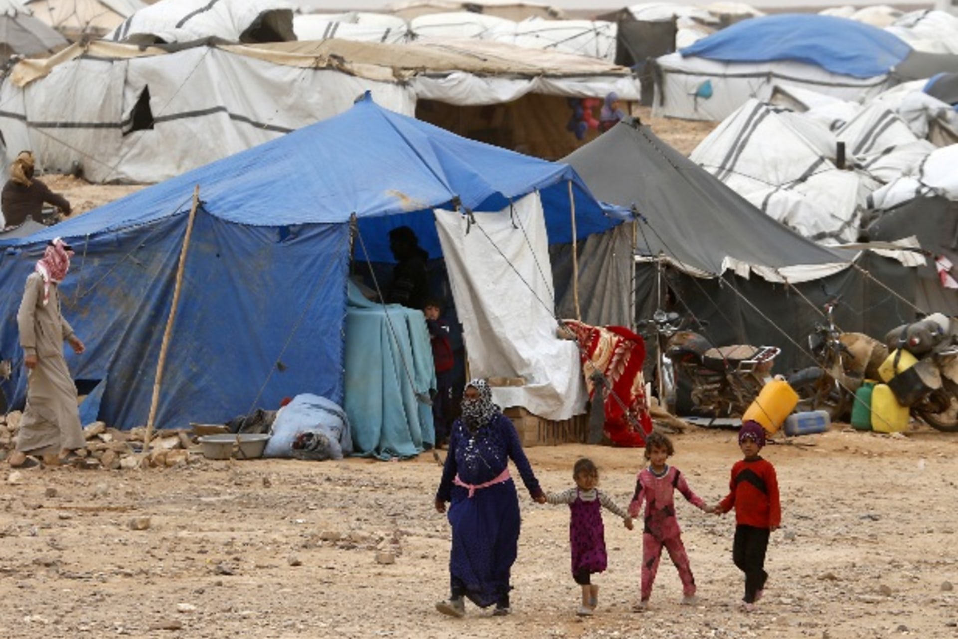<p>Syrian refugees stuck between the Jordanian and Syrian borders waiting to cross into Jordan, walk at a camp, after a group of …ian territory, near the town of Ruwaished, at the Hadalat area, east of the capital Amman, May 4, 2016. REUTERS/Muhammad Hamed</p>
