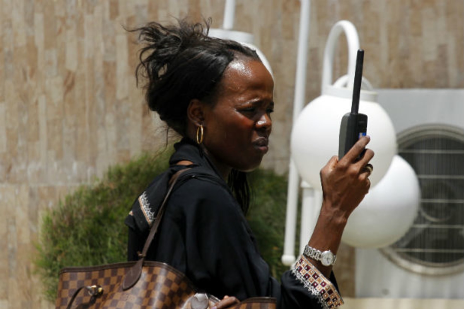 A woman tries to get reception on her mobile phone in Maiduguri, after the military declared a 24-hour curfew over large parts of the city in Borno State May 19, 2013