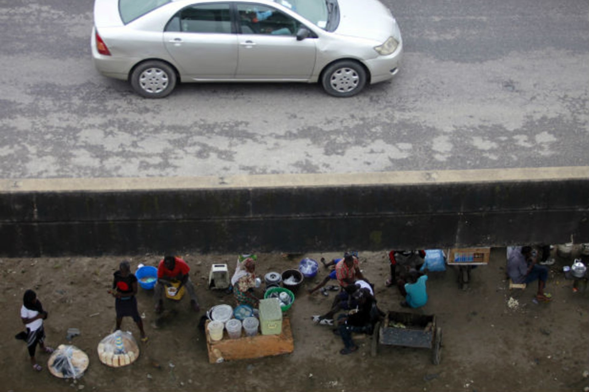 People sit and trade under a bridge at the Orile-Iganmu district of Lagos August 29, 2013