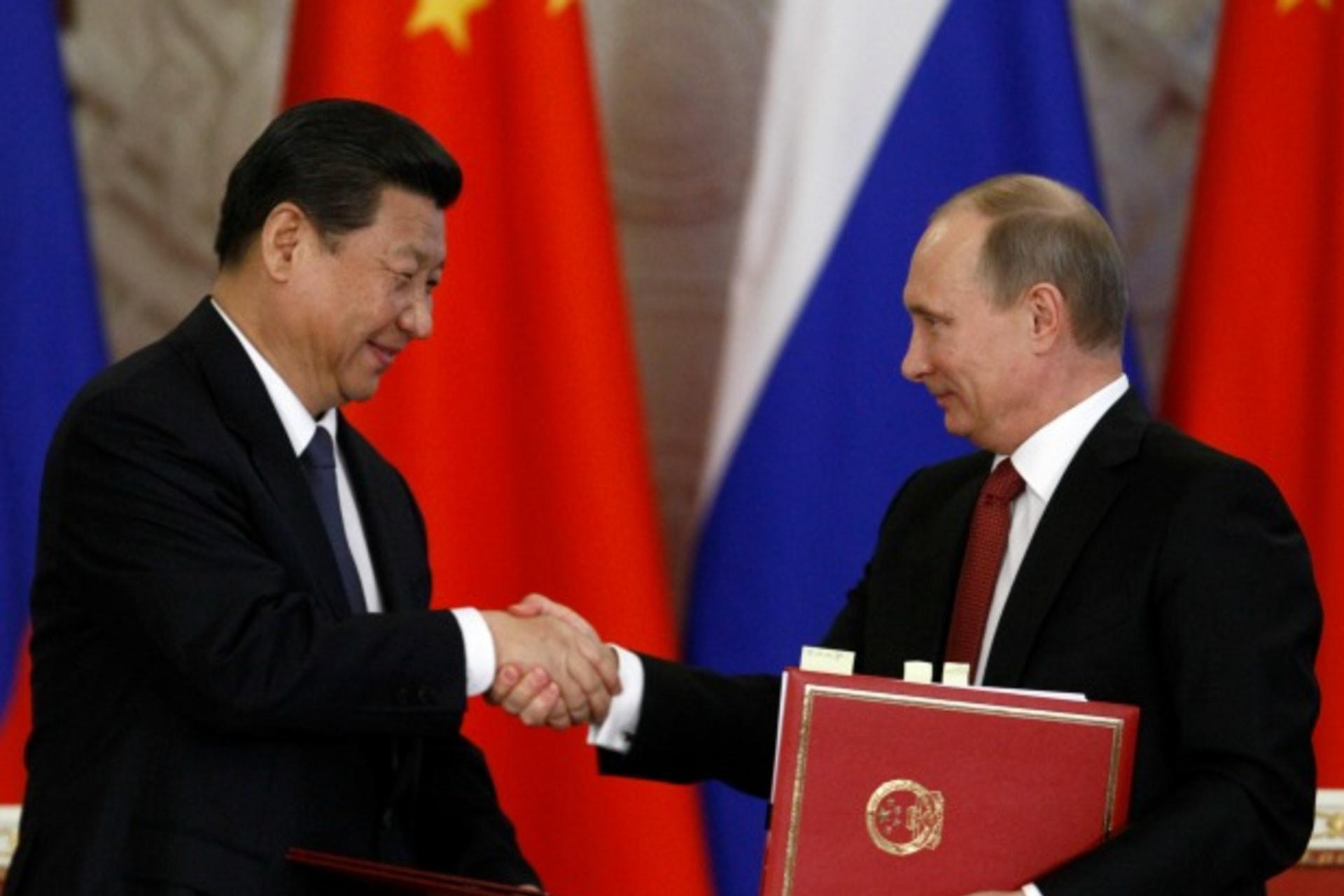 <p>Russia’s President Vladimir Putin (R) exchanges documents with his Chinese counterpart Xi Jinping during a signing ceremony at the Kremlin in Moscow on March 22, 2013.</p>
