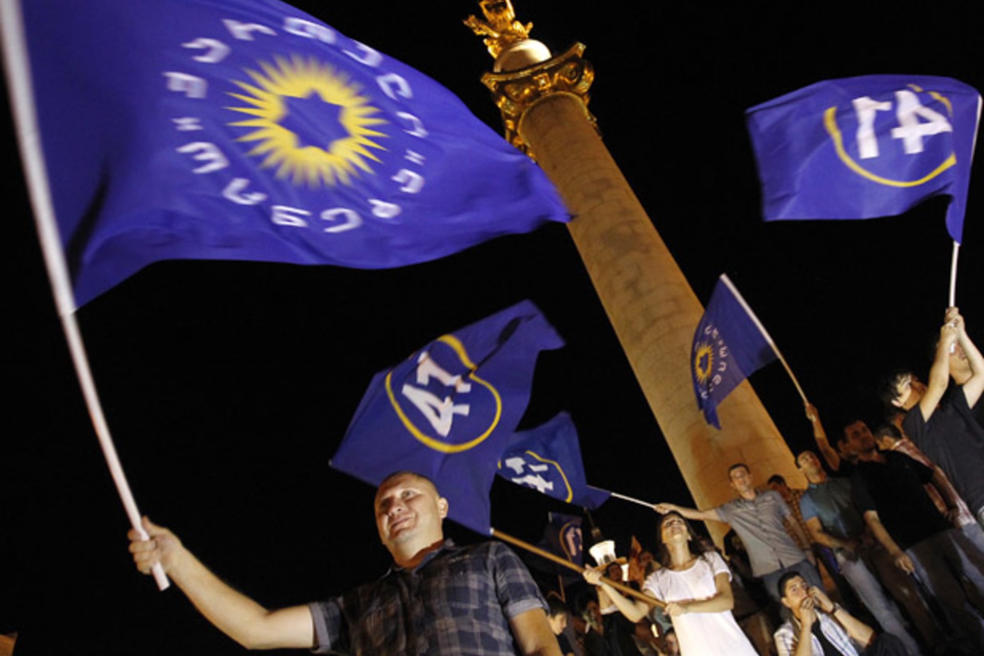 <p>Supporters of the opposition Georgian Dream coalition celebrate exit poll results in Tbilisi. (David Mdzinarishvili/ courtesy Reuters)</p>
