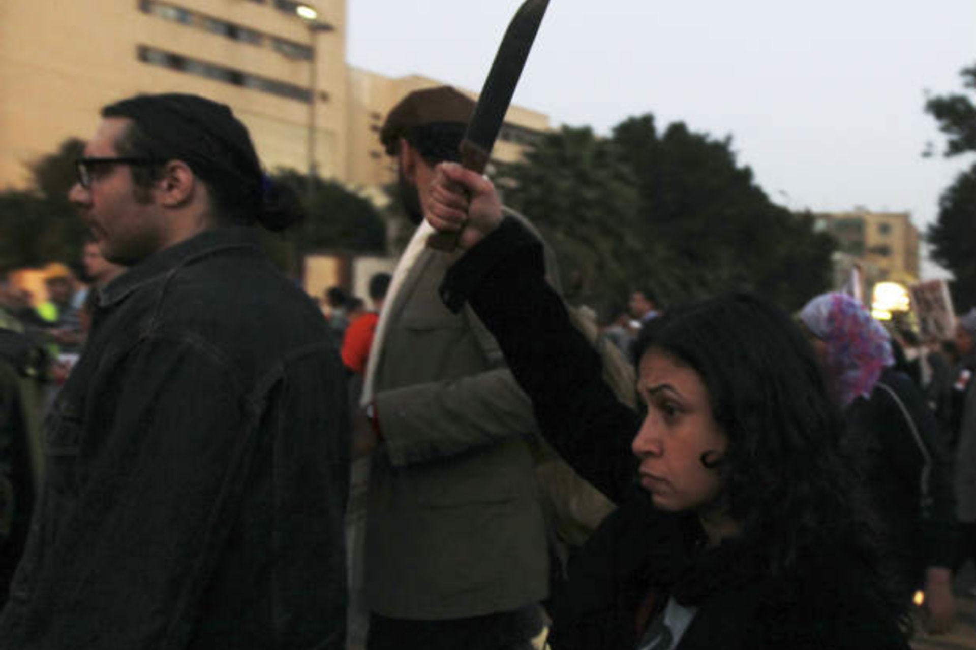 A woman raises a knife against Egyptian president Mohammed Morsi and members of the Brotherhood during a march against sexual harassment and violence against women in Cairo February 6, 2013 (Dalsh/Courtesy Reuters)..