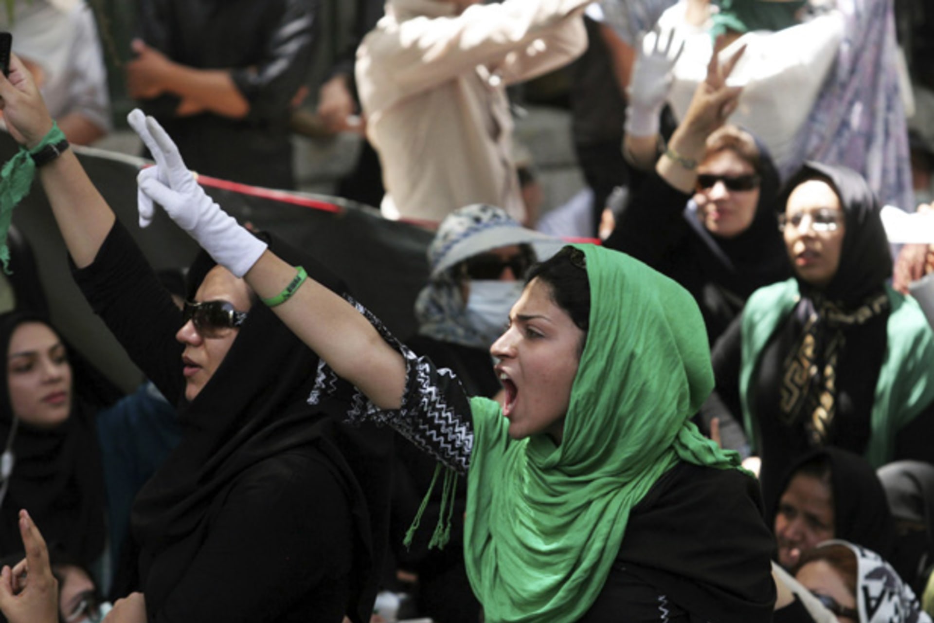 Iranian protesters flash victory signs during Friday prayers at a university in Tehran