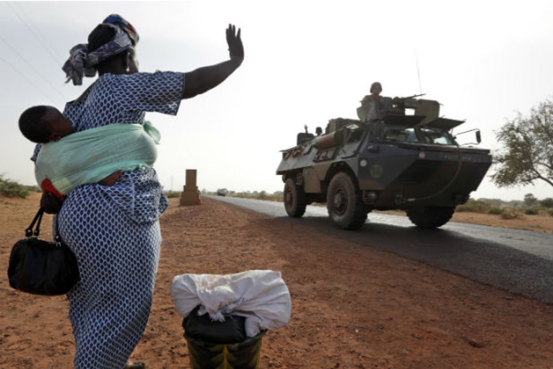 A woman waves to French soldiers heading toward the recently liberated town of Diabaly 24/01/2013.