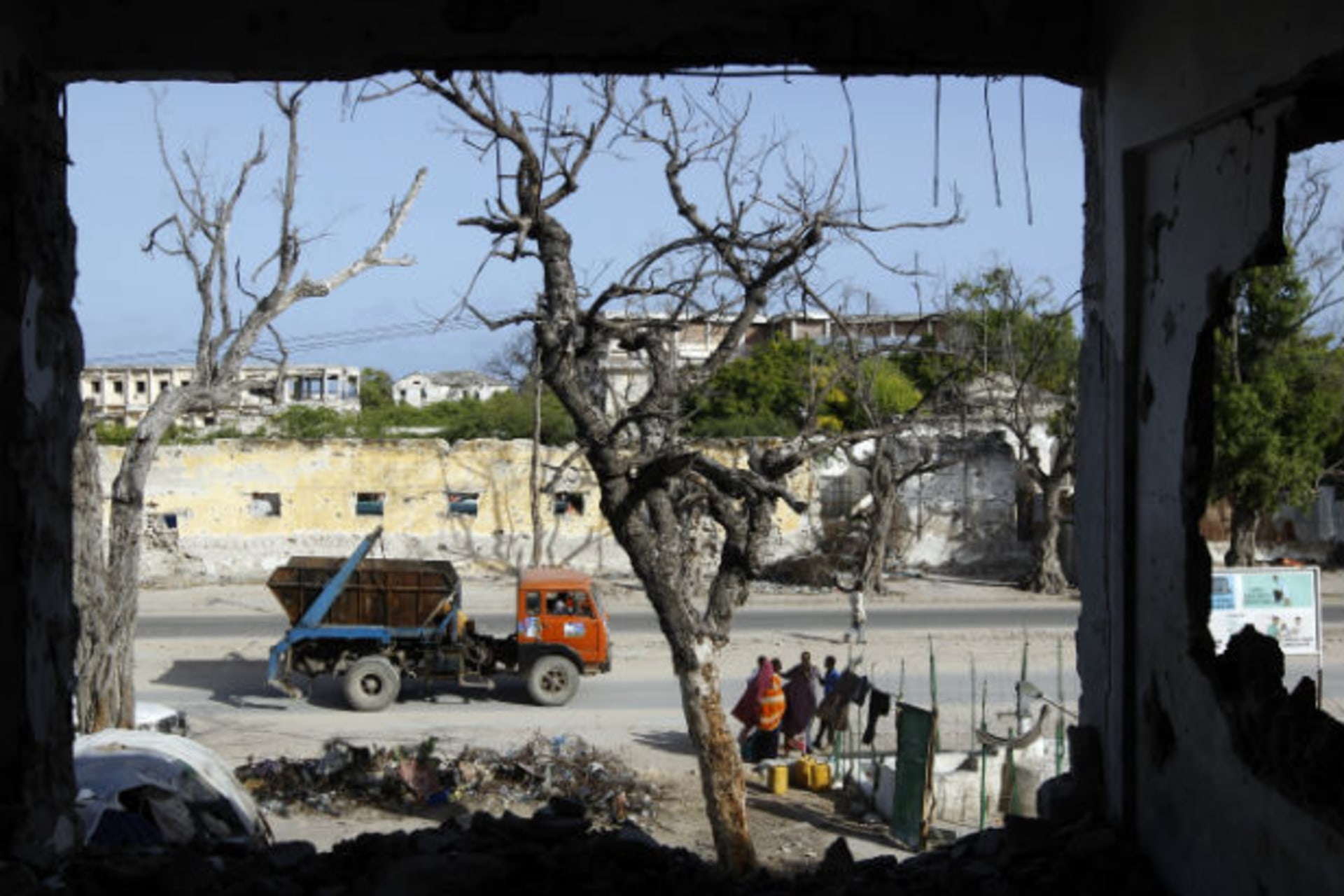 DATE IMPORTED:June 26, 2012People stand in front of a building destroyed during a fight between al Shabaab militants against African Union and Somali Government forces in Mogadishu June 26, 2012.