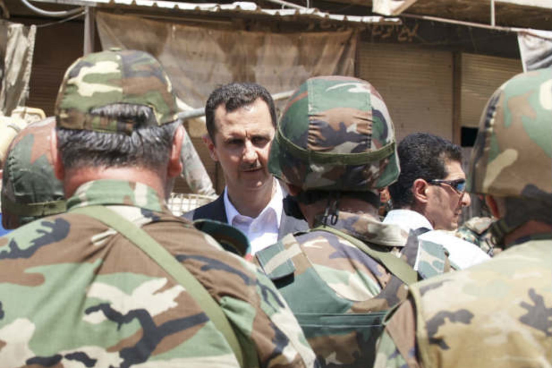 Syria's president Bashar al-Assad (C) chats with military personnel (SANA/Courtesy Reuters).