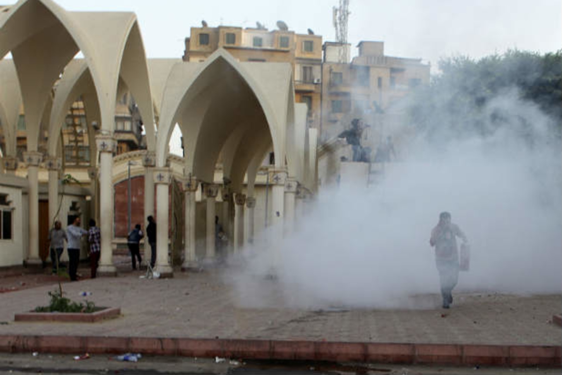 Coptic Christians run inside the main cathedral in Cairo as police fire tear gas and Muslims throw rocks and firebombs April 7, 2013 (Waguih/Courtesy Reuters)..