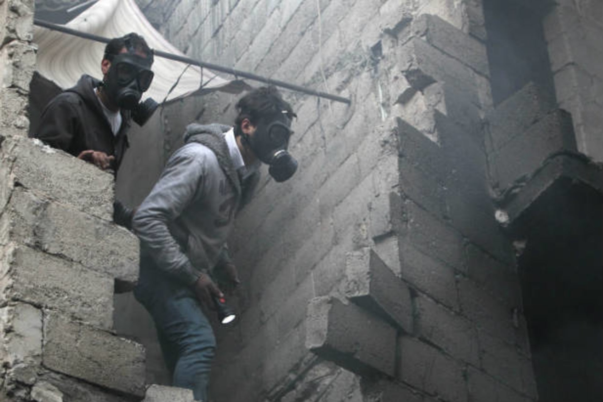 Residents wear masks as they search for bodies in Aleppo (Salman/Courtesy Reuters).
