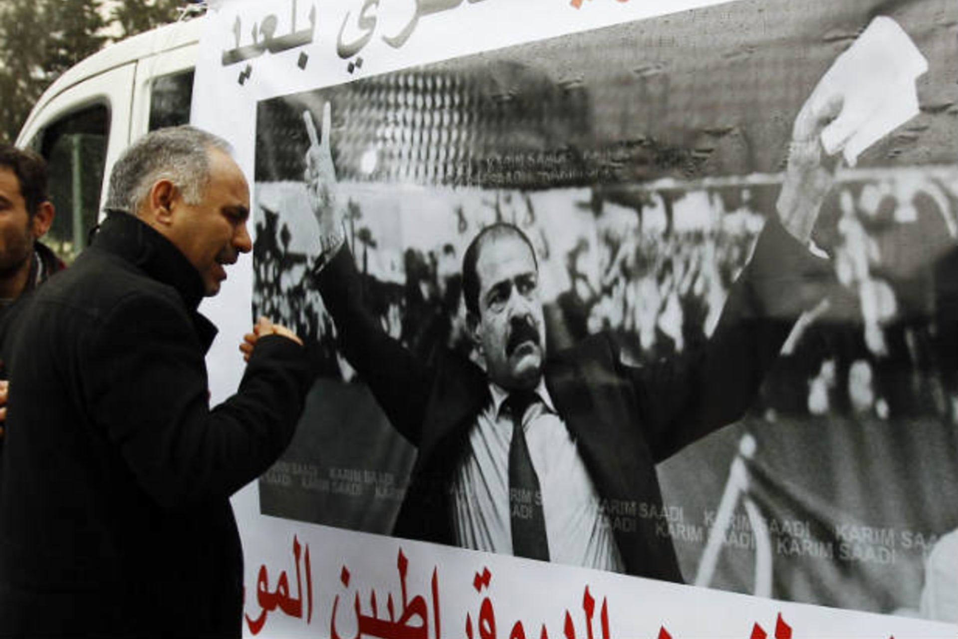 A man cries next to a poster with an image of Chokri Belaid, a prominent Tunisian opposition politician who was shot dead, in Tunis February 7, 2013 (Souissi/Courtesy Reuters).