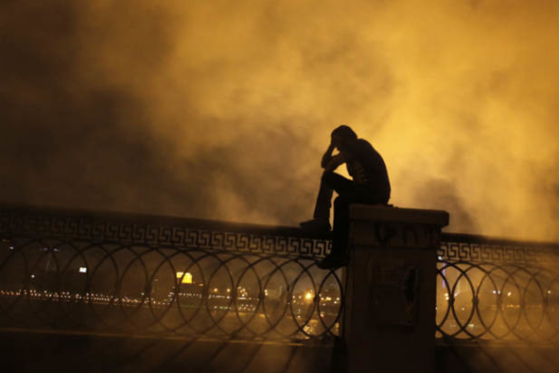 A protester covers his face as he stands in front of tear gas during clashes with riot police along a road that leads to the U.S. embassy, near Tahrir Square in Cairo on September 15, 2012 (Dalsh/Courtesy Reuters).