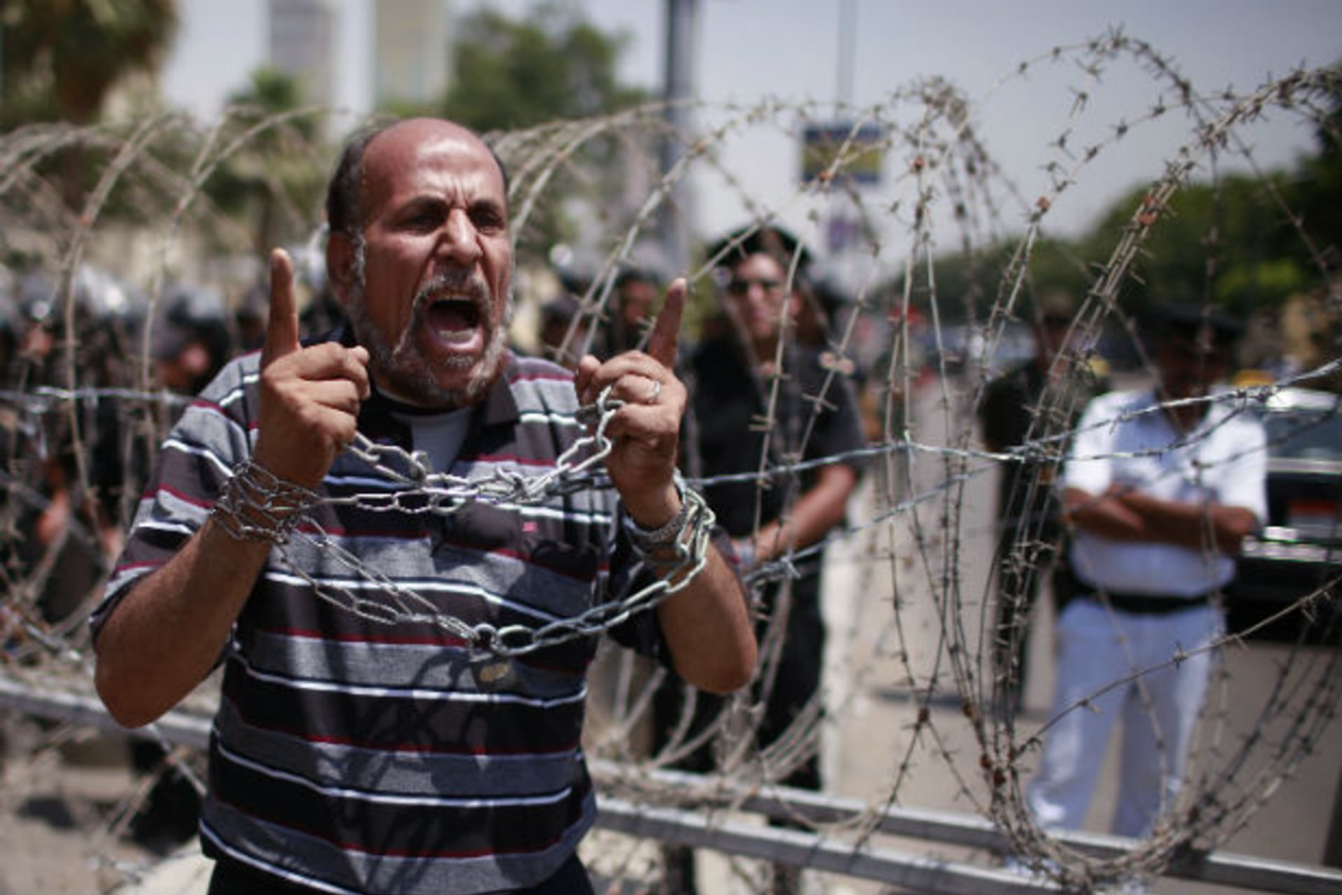 A protester shouts in front of police outside the Supreme Constitutional Court, where a decision is expected on the validity of the law passed by the Islamist-led parliament that sought to bar Ahmed Shafik in Cairo June 14, 2012 (Suhaib Salem/