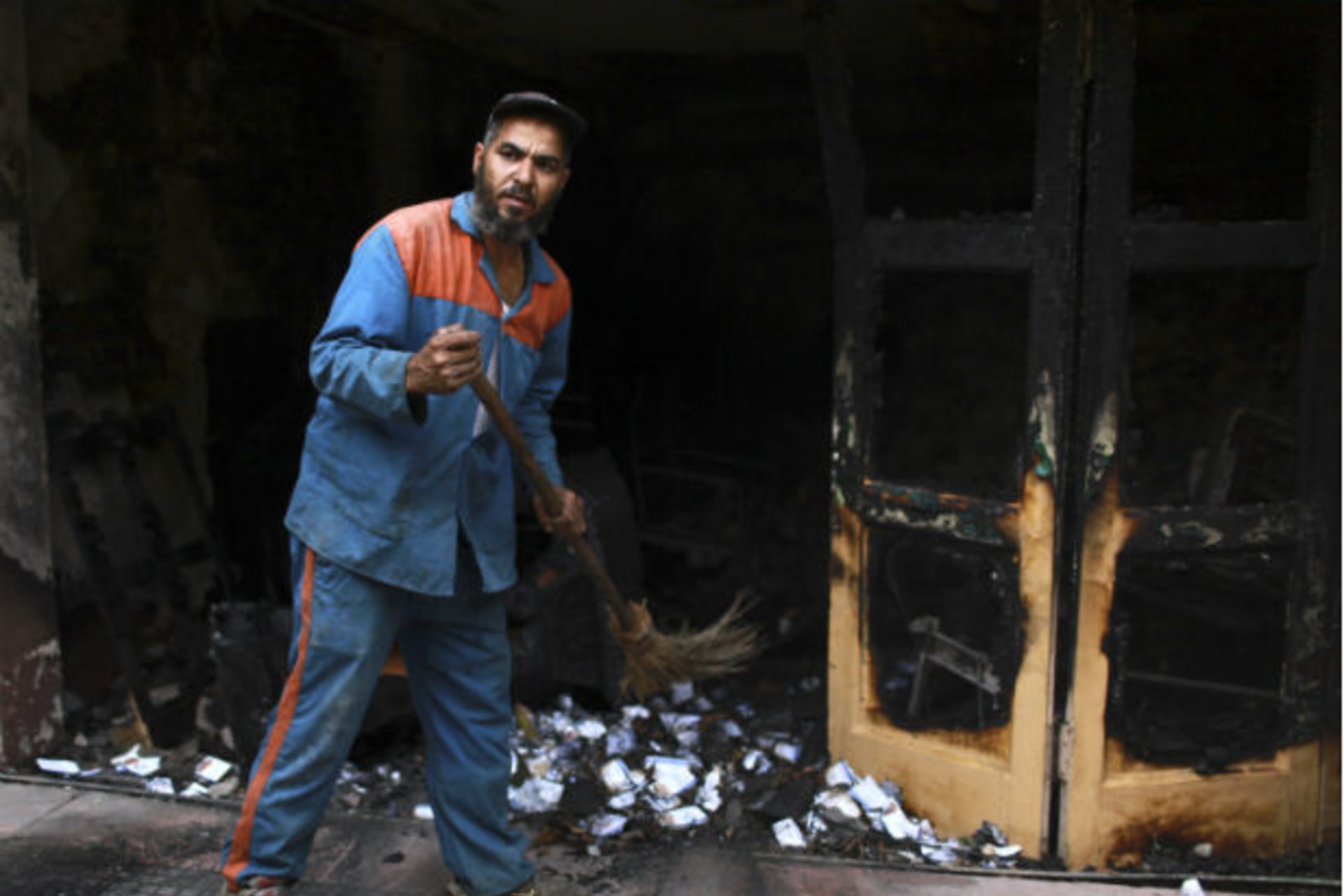 A man cleans the scene of the burnt campaign headquarters of presidential candidate Ahmed Shafiq in Cairo on May 29, 2012 (Mohammed Salem/Courtesy Reuters).