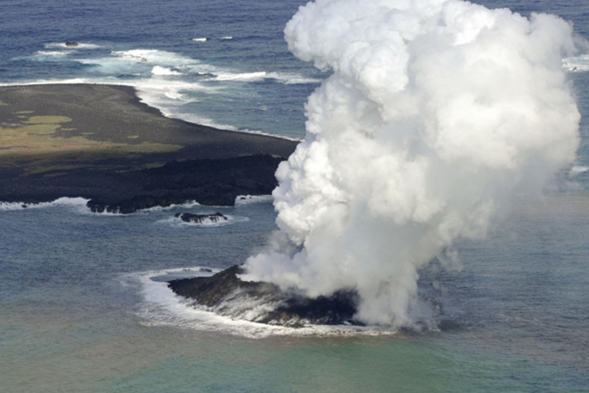 <p>Smoke from an erupting undersea volcano forms a new island off the coast of Nishinoshima (top L), a small uninhabited island, in the southern Ogasawara chain of islands in this November 21, 2013</p>
