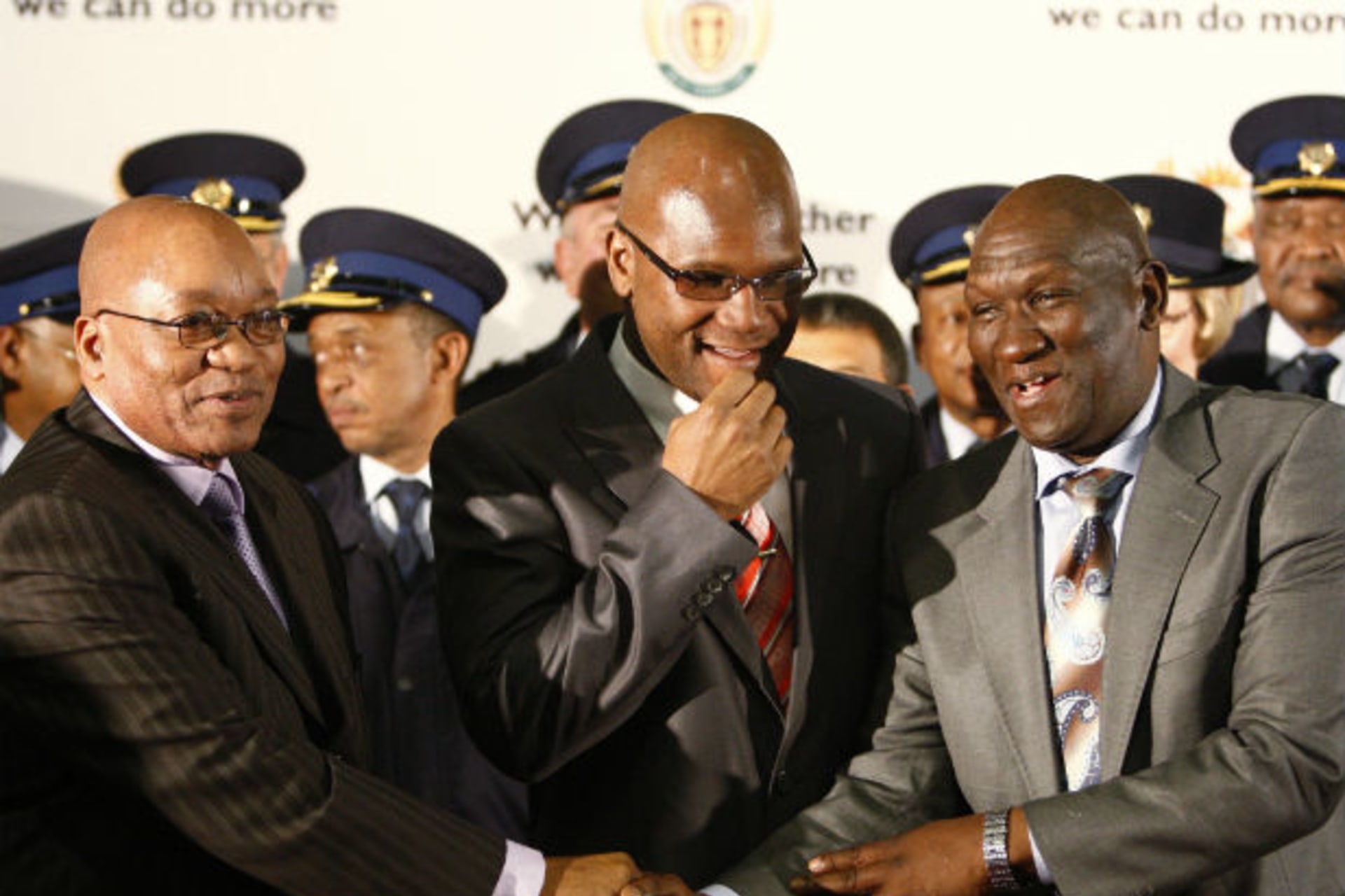 Newly appointed South African national police commissioner, Bheki Cele (R), is congratulated by South African President Jacob Zuma as Safety and Security Minister Nathi Mthethwa (C) looks on at the end of the news conference in Pretoria, July 2